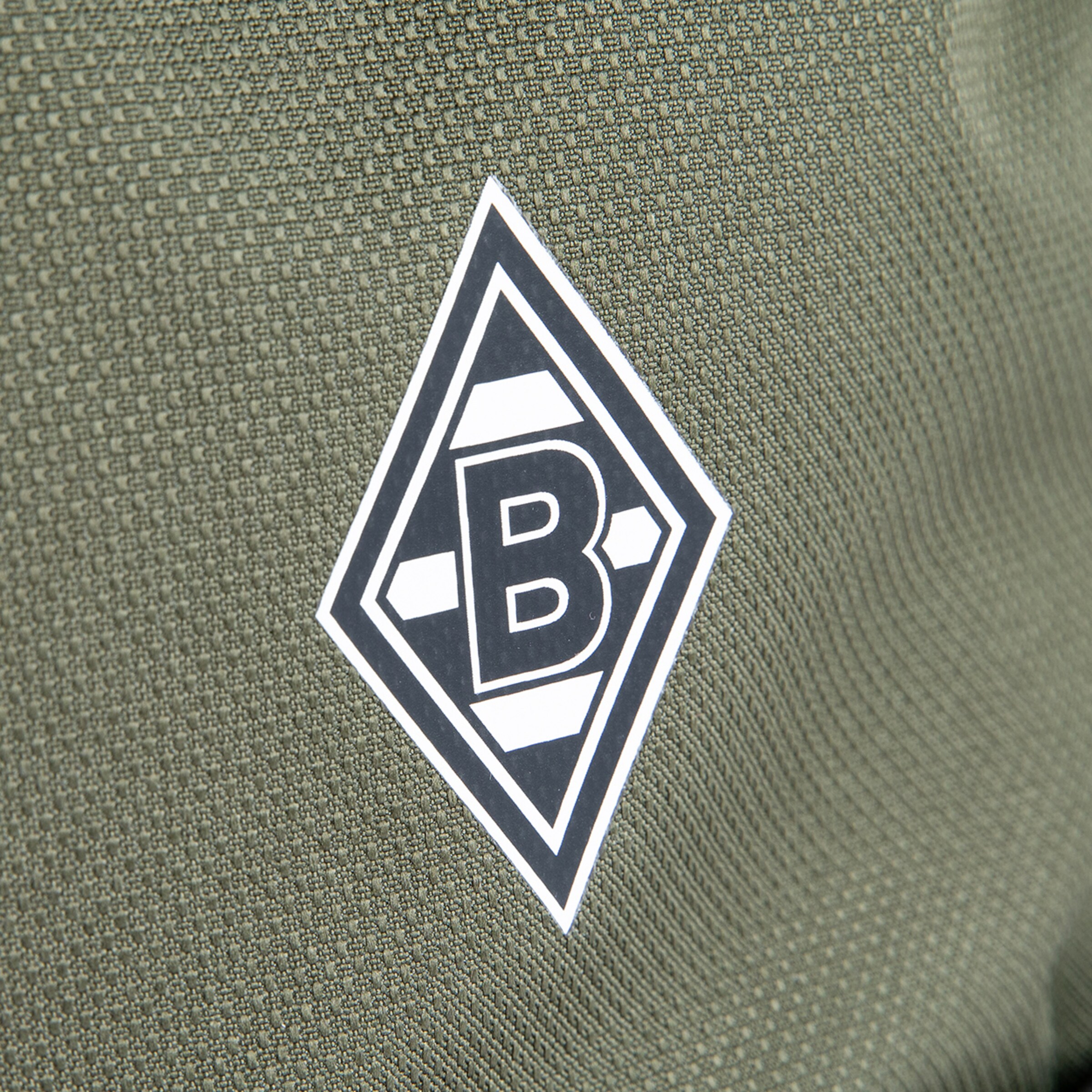 Das Logo von Borussia Mönchengladbach auf einem grünem Trikot.