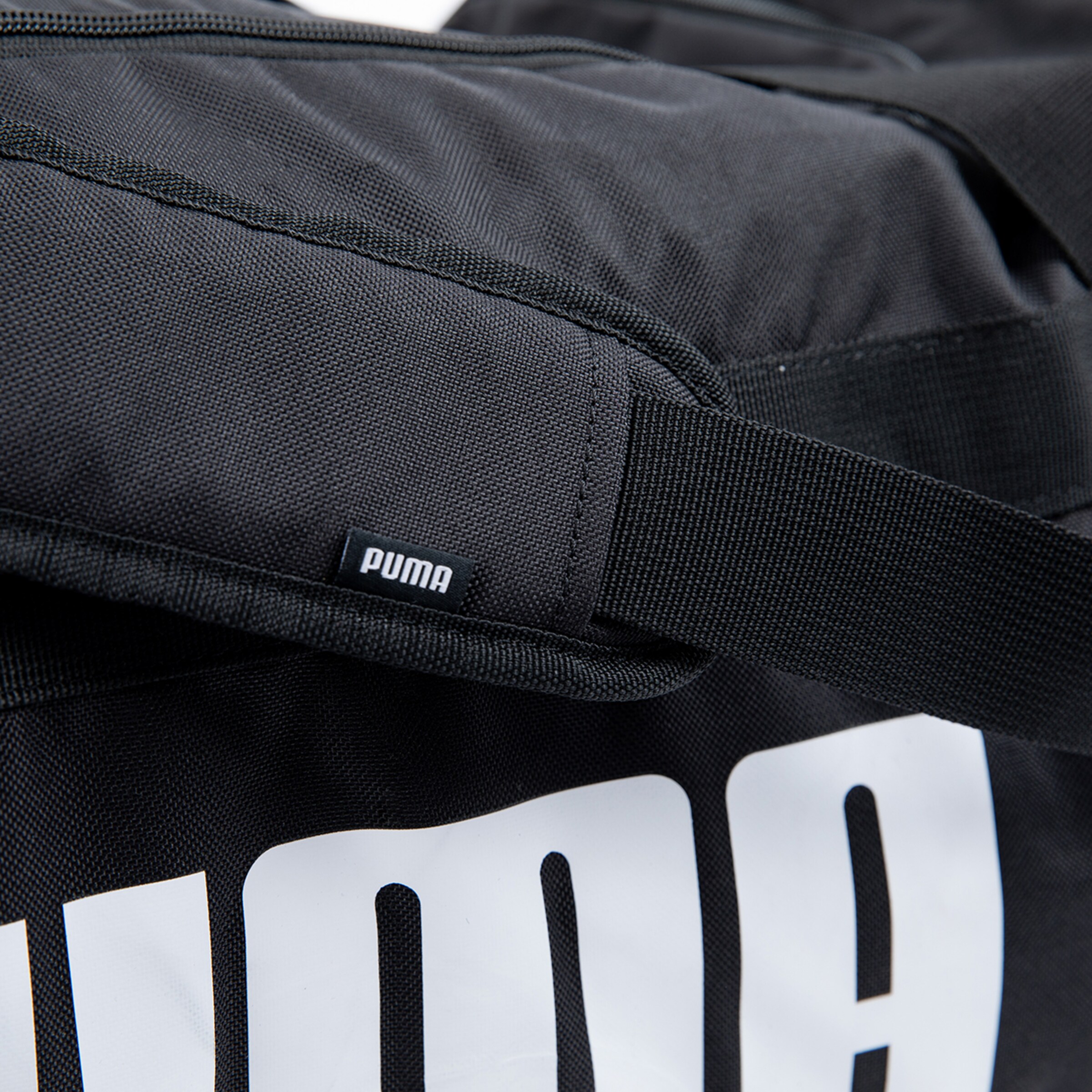 Schwarze Sporttasche mit einem weißen Puma-Logo auf der Seite.