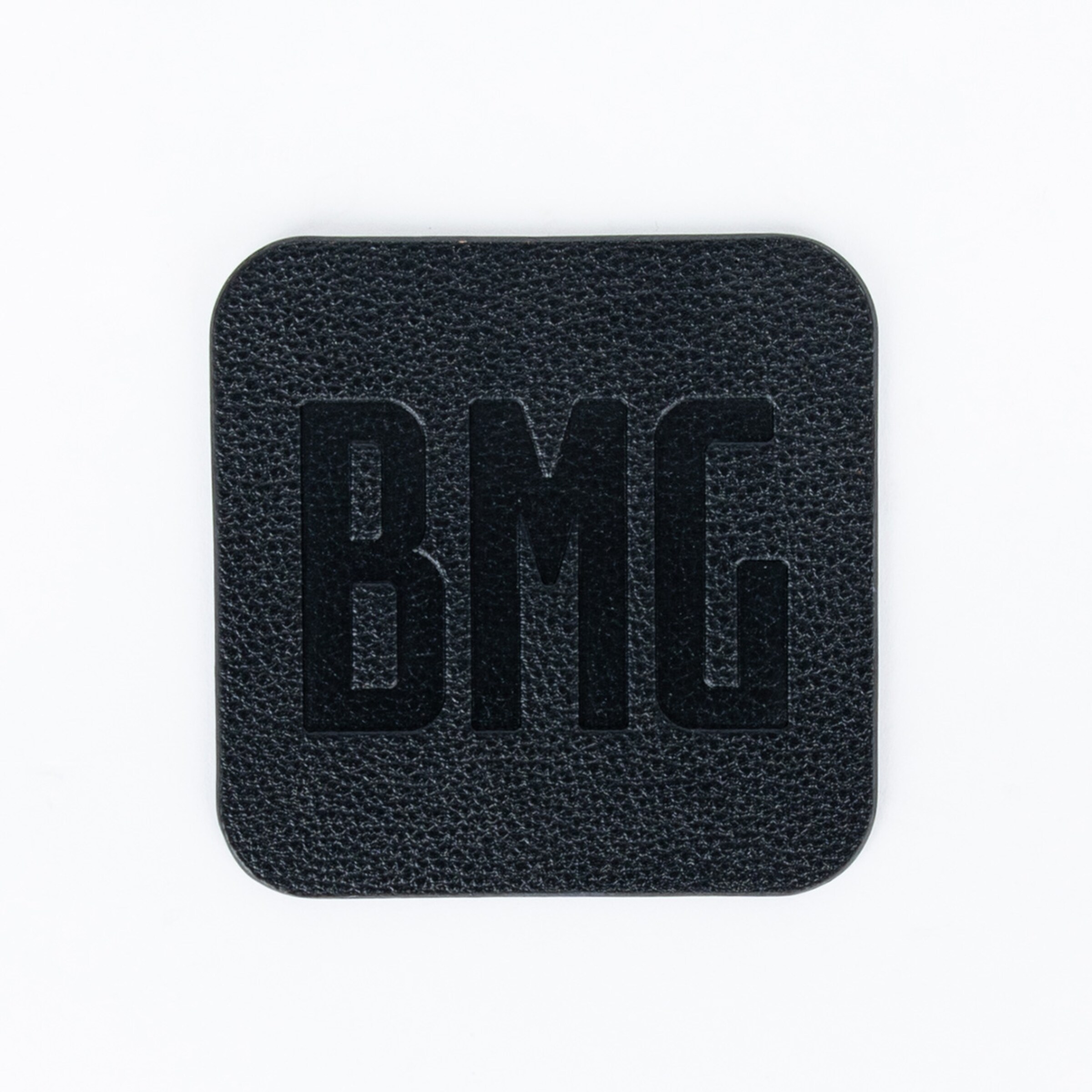 Black square leather patch featuring the embossed letters BMG in bold.