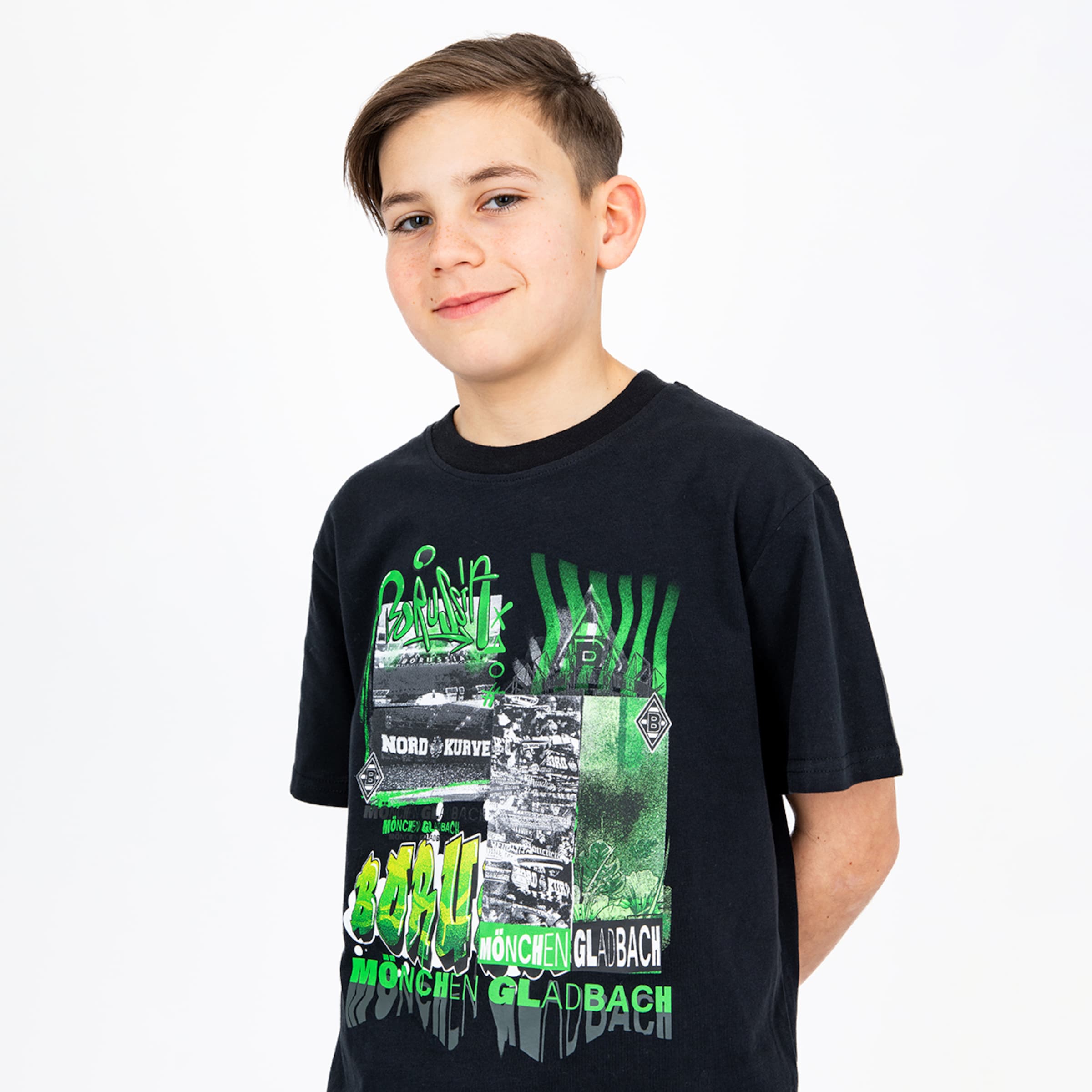 Junge mit einem schwarzen T-Shirt das den Schriftzug Borussia Mönchengladbach in grün zeigt.