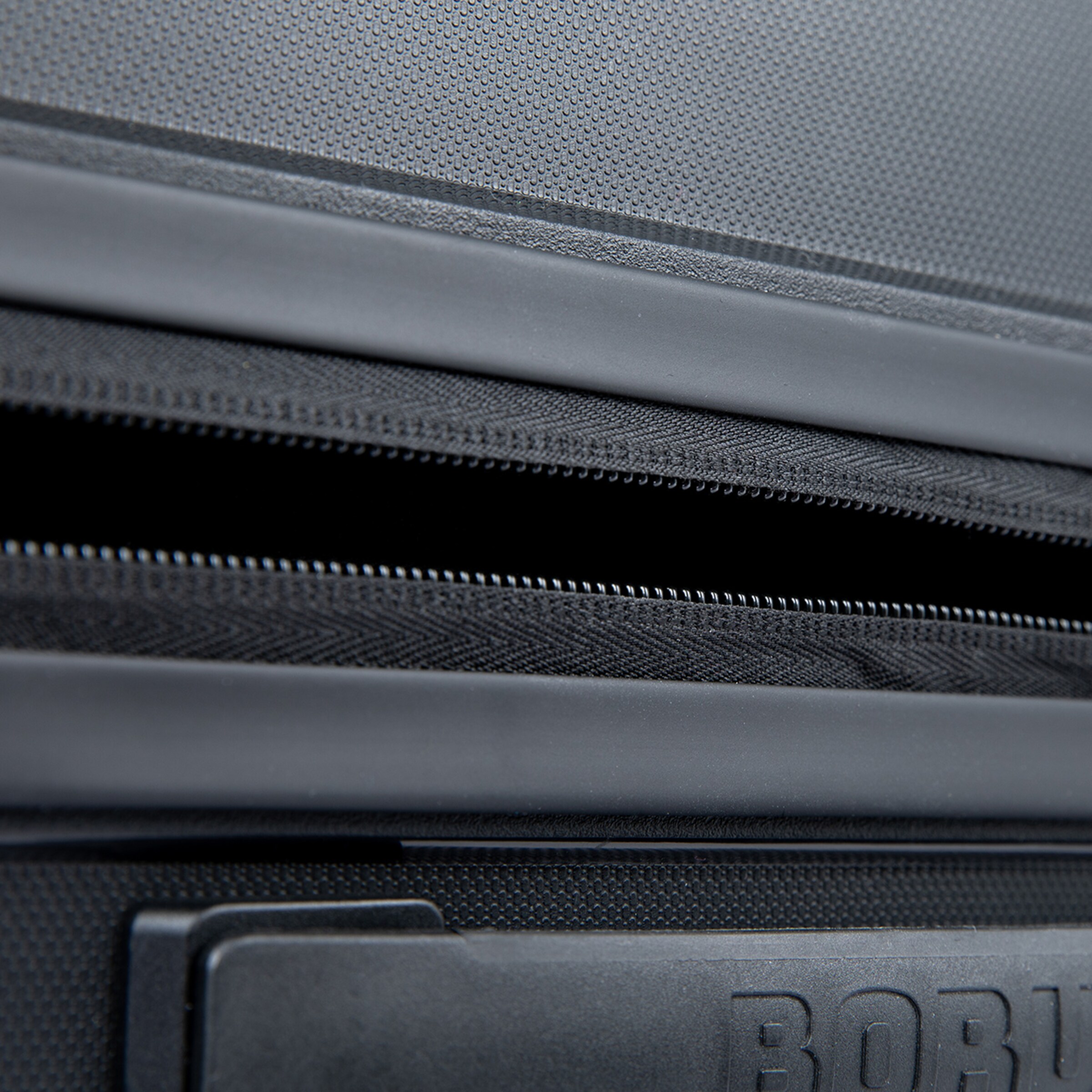 Detailaufnahme des Reißverschlusses einer schwarzen Reisetasche von Borussia Mönchengladbach.
