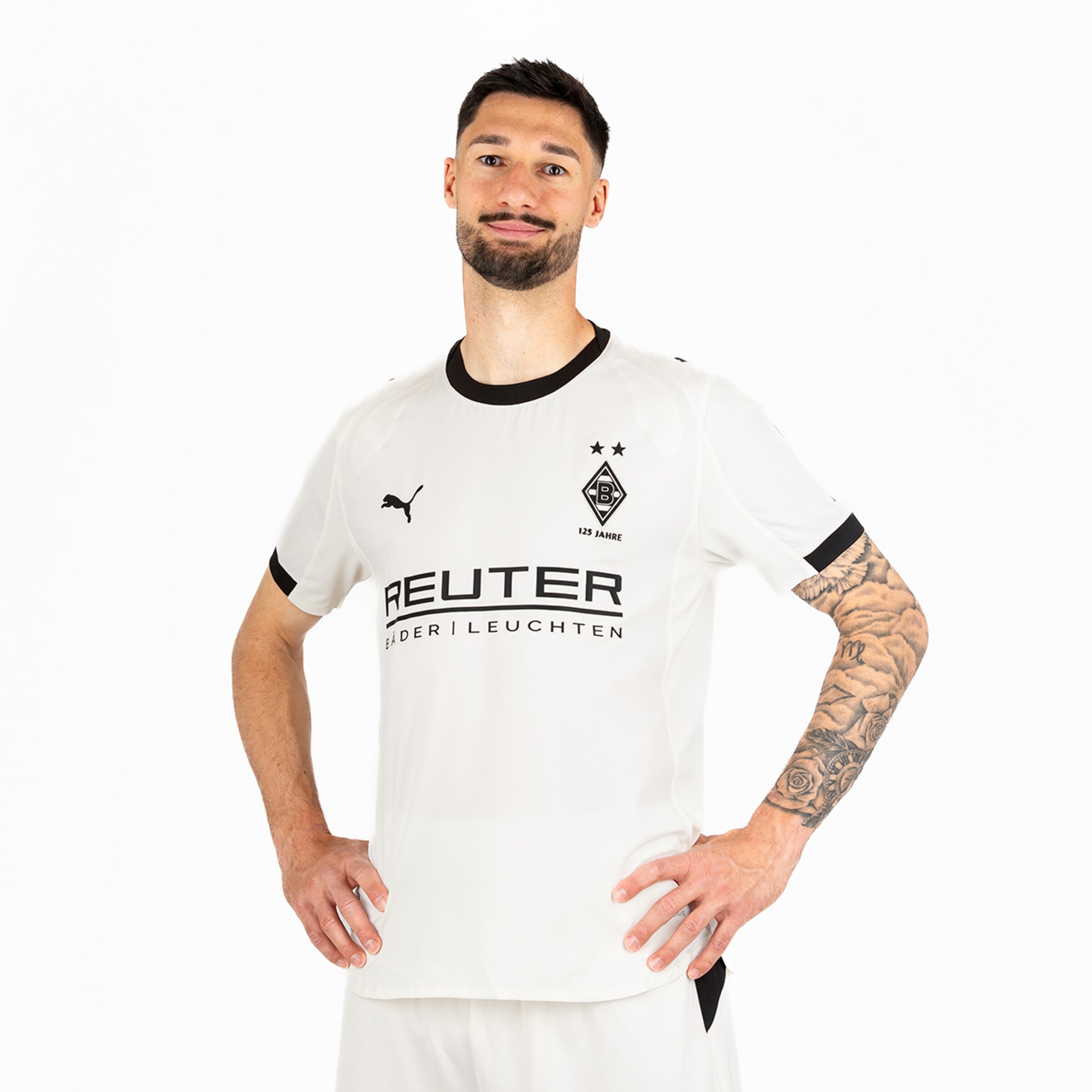 Fußballspieler in weißem Borussia Mönchengladbach-Trikot mit schwarzem Logo und Sponsorenaufschrift.