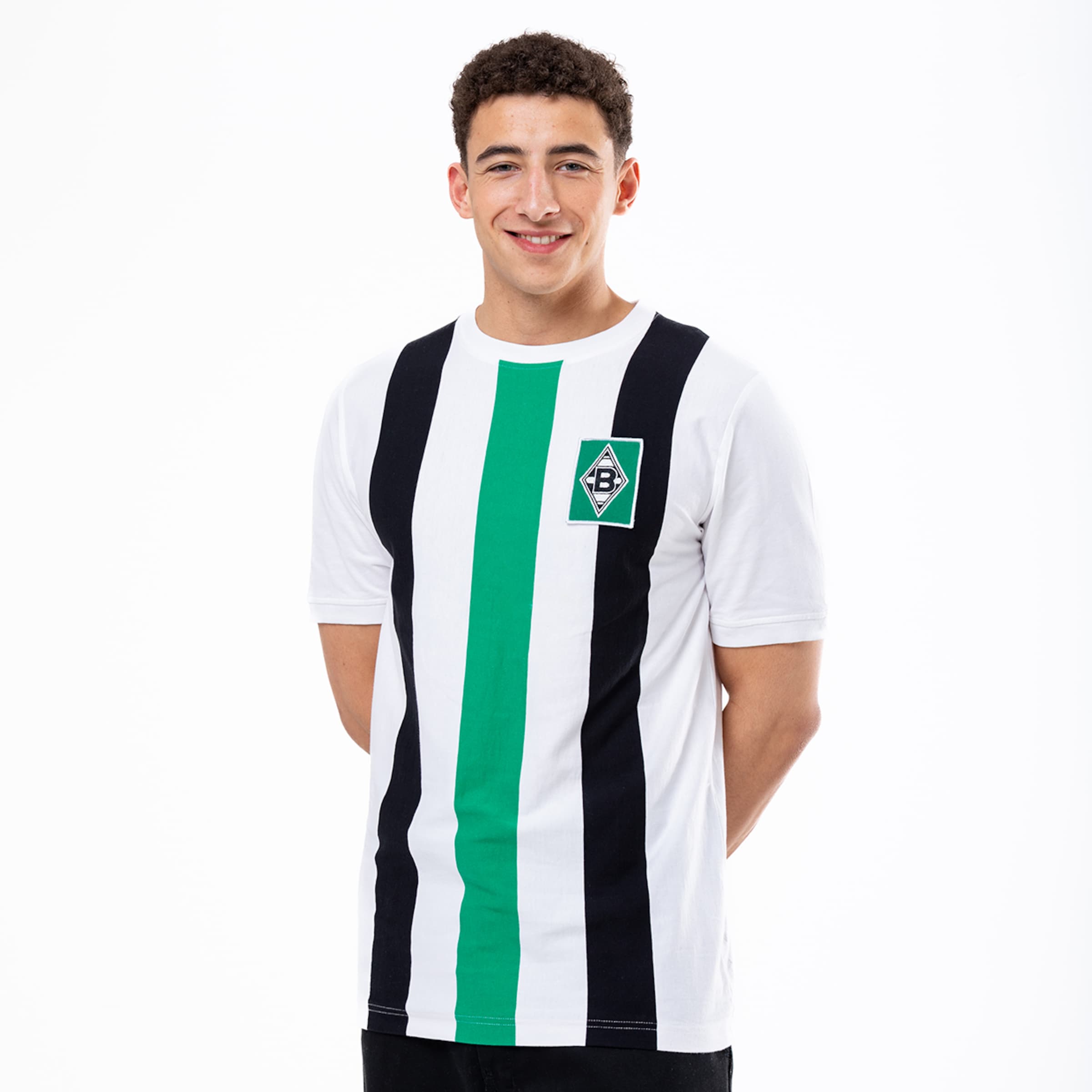 Ein junger Mann trägt ein Borussia Mönchengladbach Trikot mit schwarz-weißen Streifen und grünem Mittelstreifen.