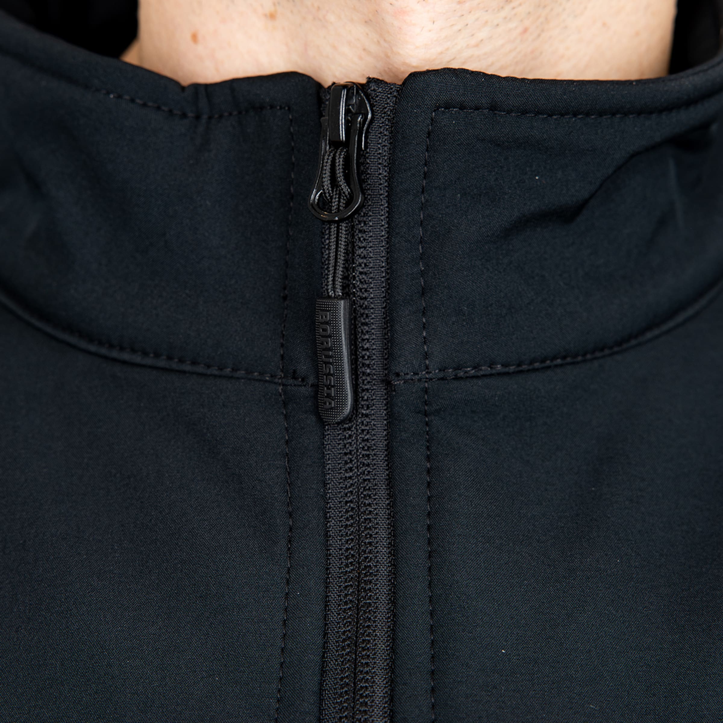 Nahaufnahme eines schwarzen Reißverschlusses mit vertikalem „BORUSSIA“-Schriftzug auf dem Schieber.