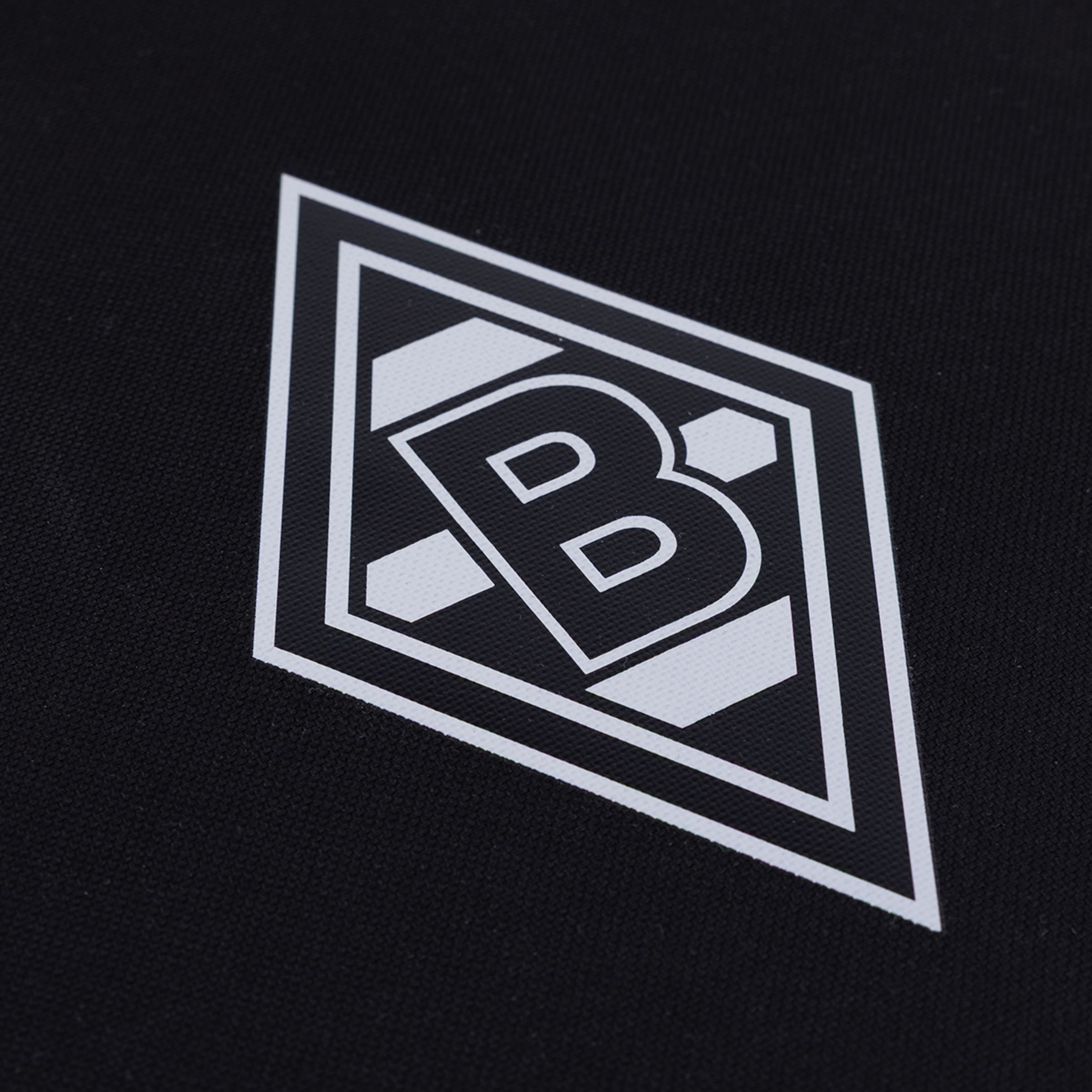 Weißes Logo von Borussia Mönchengladbach, eine Raute mit dem Buchstaben B, auf schwarzem Stoff.