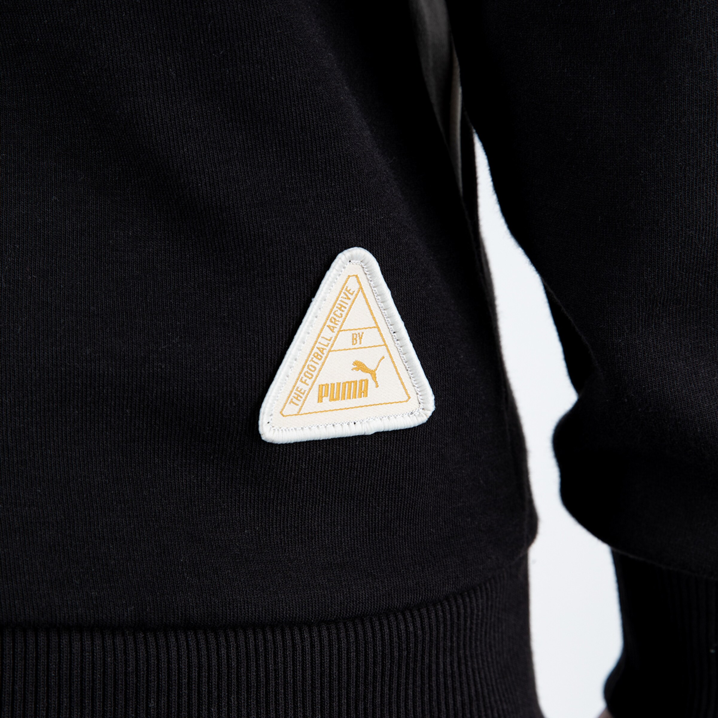 Schwarzes Sweatshirt mit weißem PUMA-Etikett in Form eines Dreiecks.