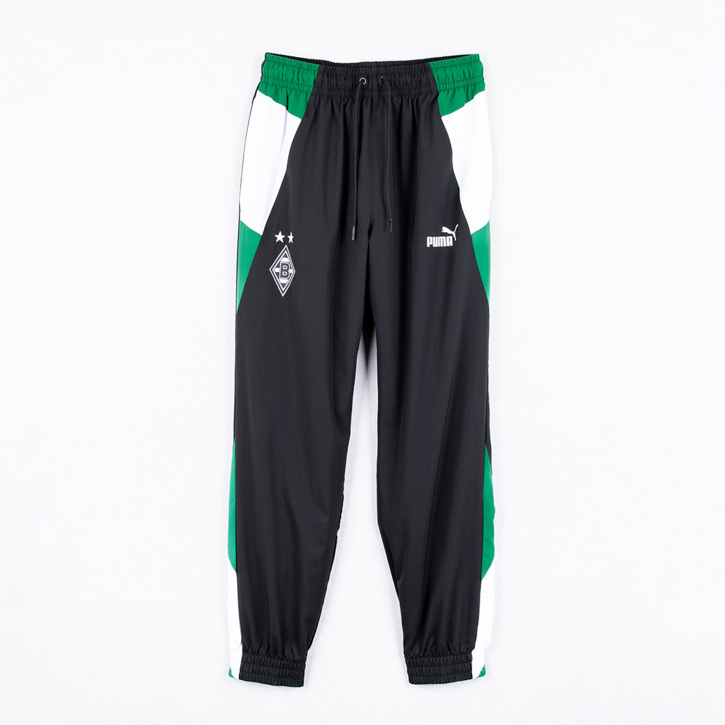 Schwarze Puma Trainingshose von Borussia Mönchengladbach mit grün-weißen Seitenstreifen, Vereinswappen und Markenlogo.