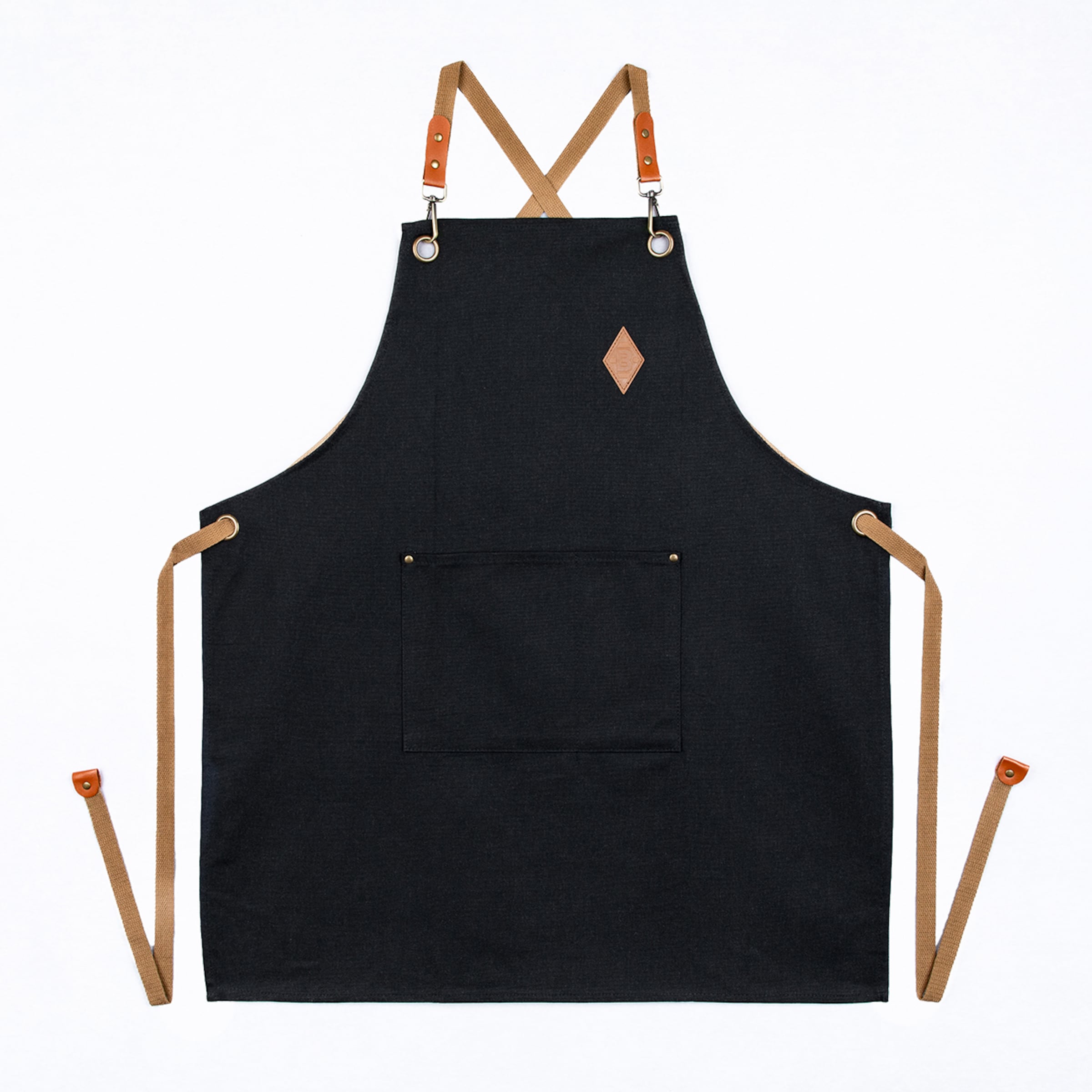 Black canvas apron with tan leather-trimmed criss-cross straps, waist ties, a front pocket, and a diamond logo patch, displayed on a white background.