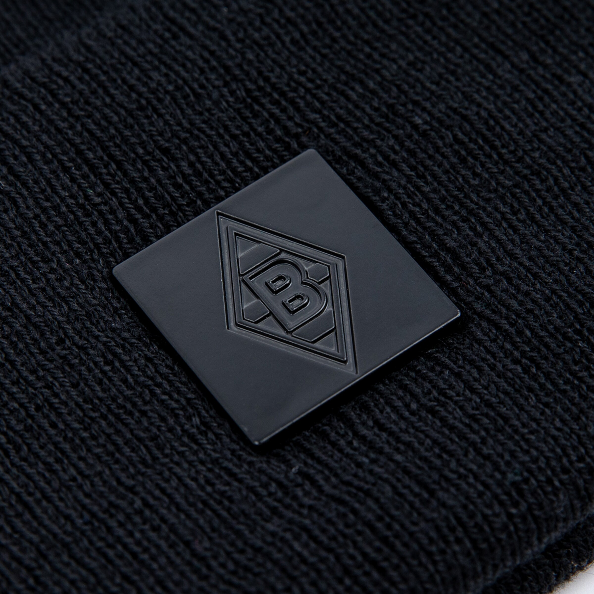 Schwarzes Patch mit dem Logo von Borussia Mönchengladbach auf schwarzem Strickstoff.