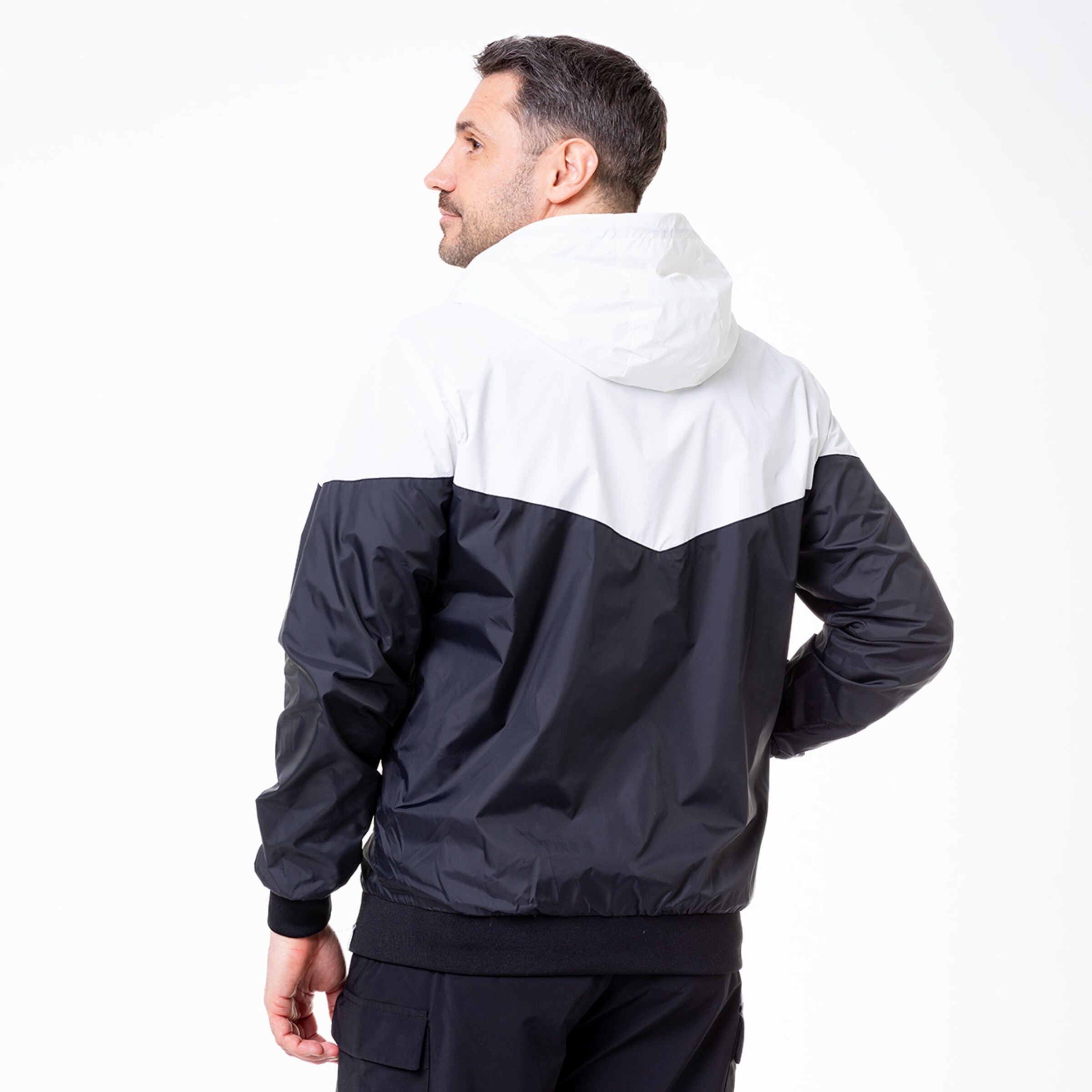 Man wearing a black and white hooded jacket viewed from the back