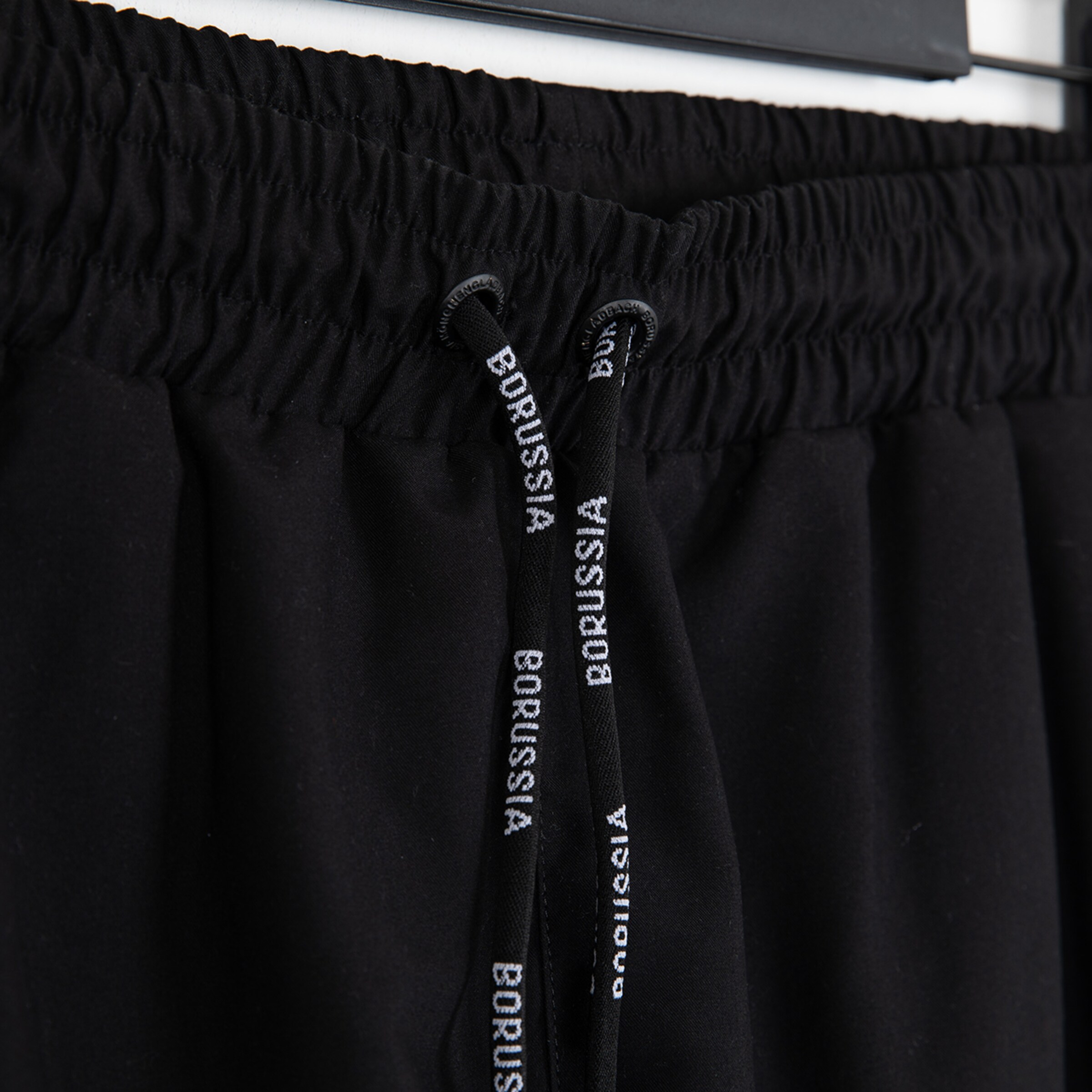 Schwarze Sporthose mit Gummizug und Bindeband beschriftet mit BORUSSIA.