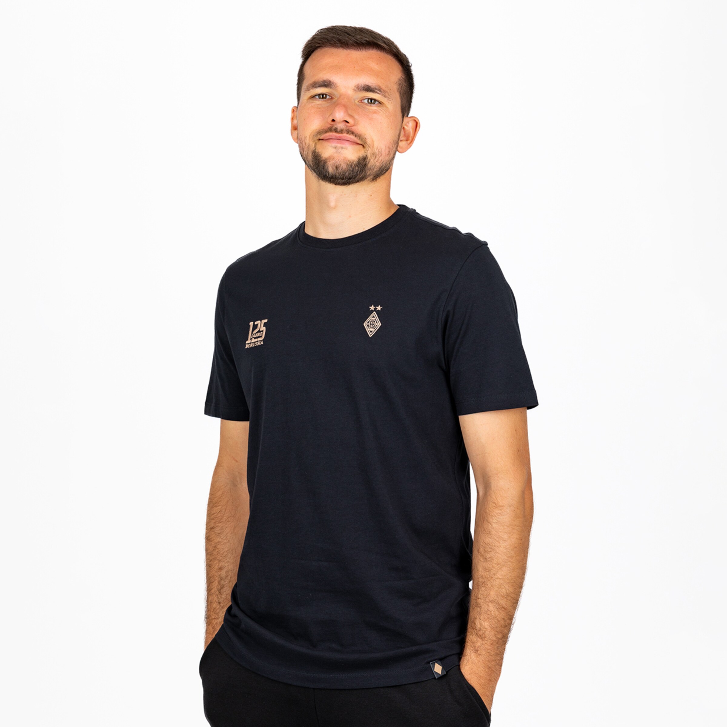 Julian Weigl im schwarzen T-Shirt mit Borussia Mönchengladbach-Logos zum 125. Jubiläum vor weißem Hintergrund.