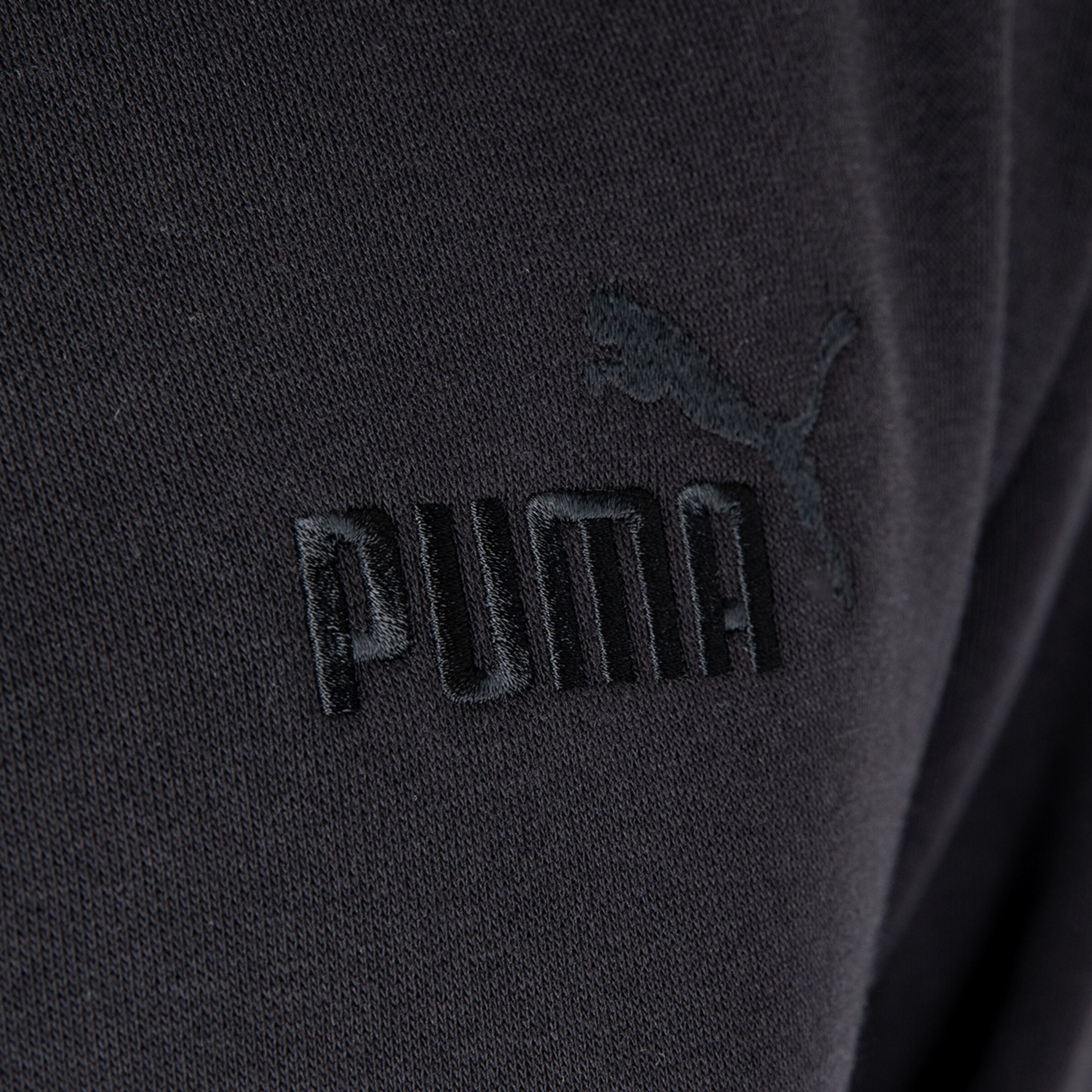 Logo des Sportbekleidungsherstellers Puma auf schwarzem Stoff