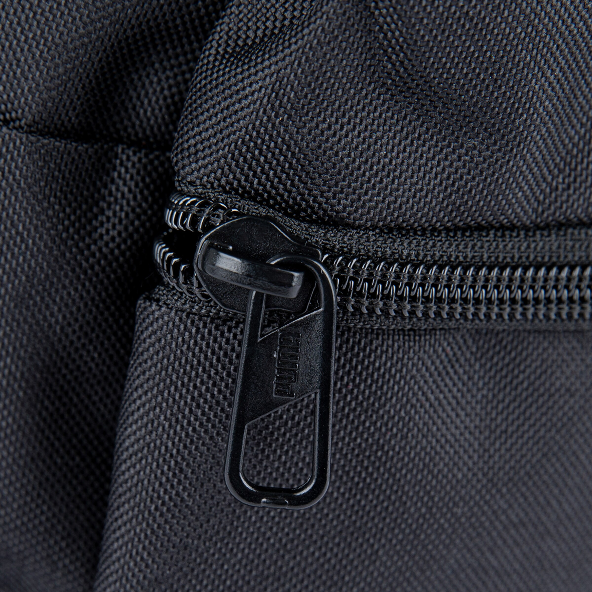 Nahaufnahme eines schwarzen Reißverschlusses auf einem Stoffbeutel.