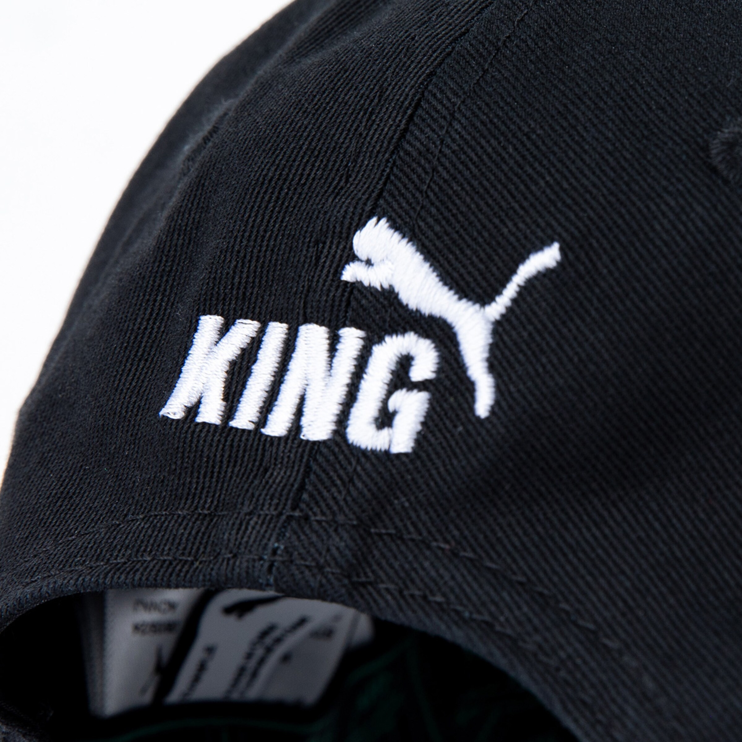 Schwarze Kappe mit weißen Schriftzug KING und Puma-Logo.