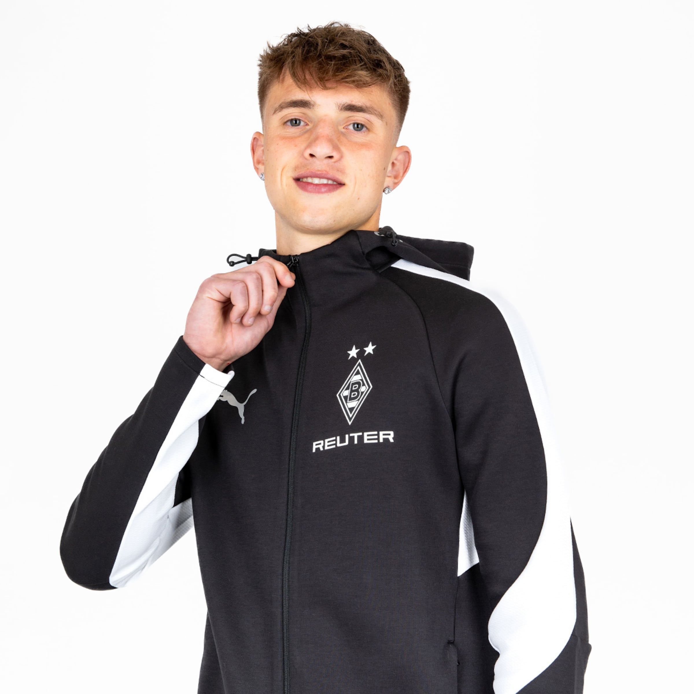 Junger Mann trägt eine schwarze Puma-Jacke mit Borussia Mönchengladbach-Logo.