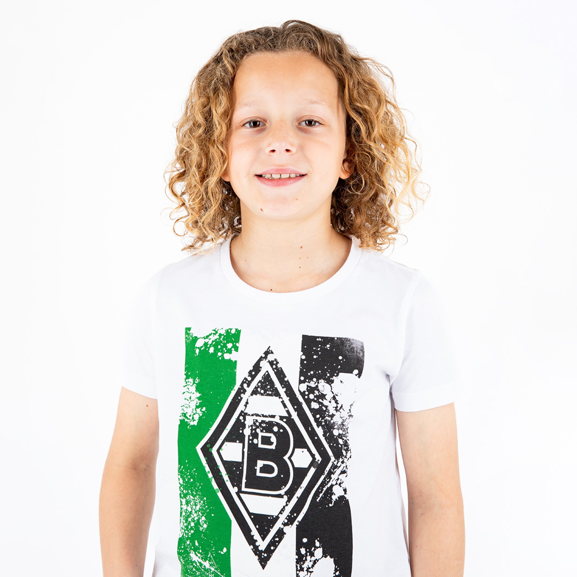 Ein lächelndes Kind mit lockigem blondem Haar trägt ein weißes T-Shirt mit einem grafischen Design in den Vereinsfarben von Borussia Mönchengladbach.