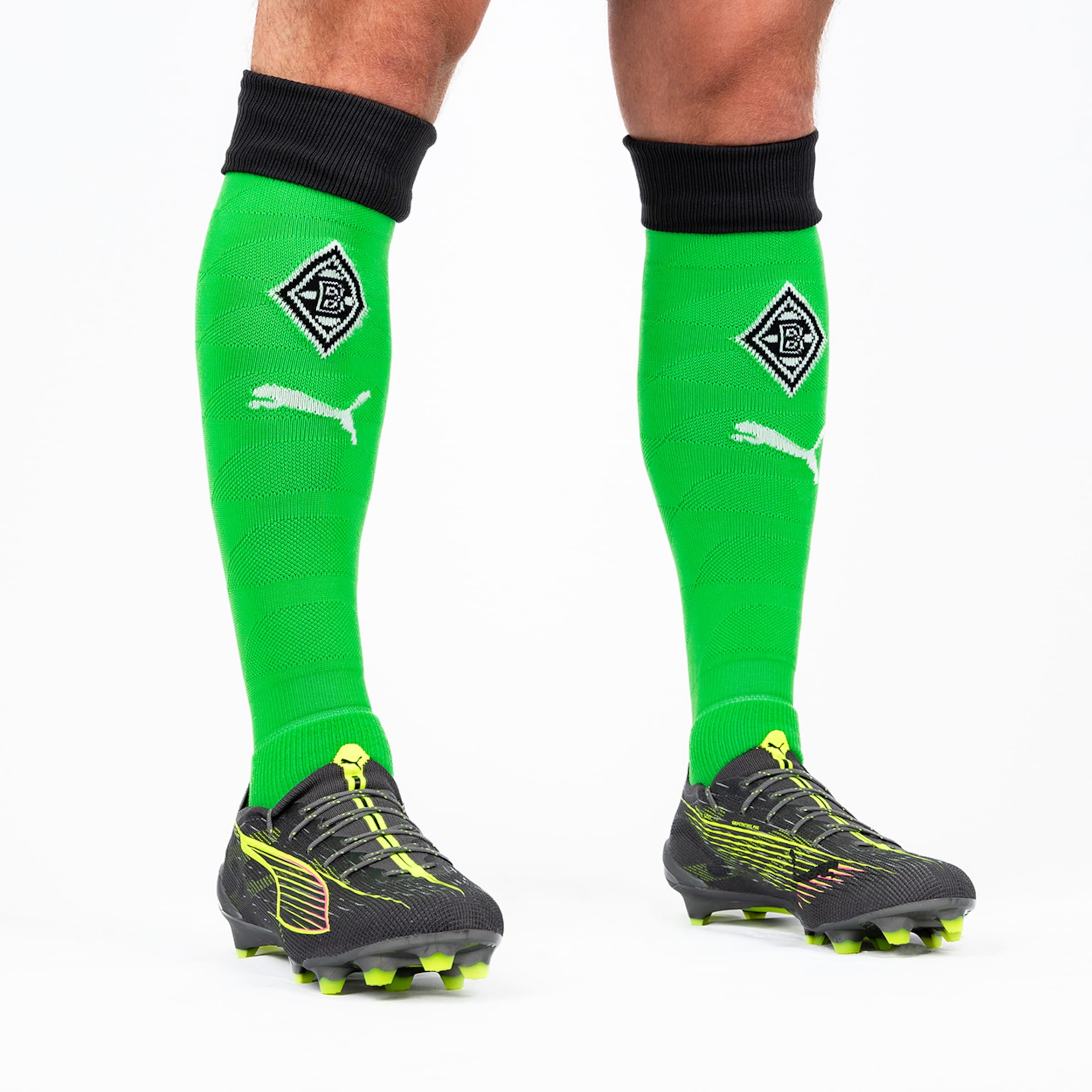 Black football boots with green Borussia Mönchengladbach sock design featuring Puma logo.