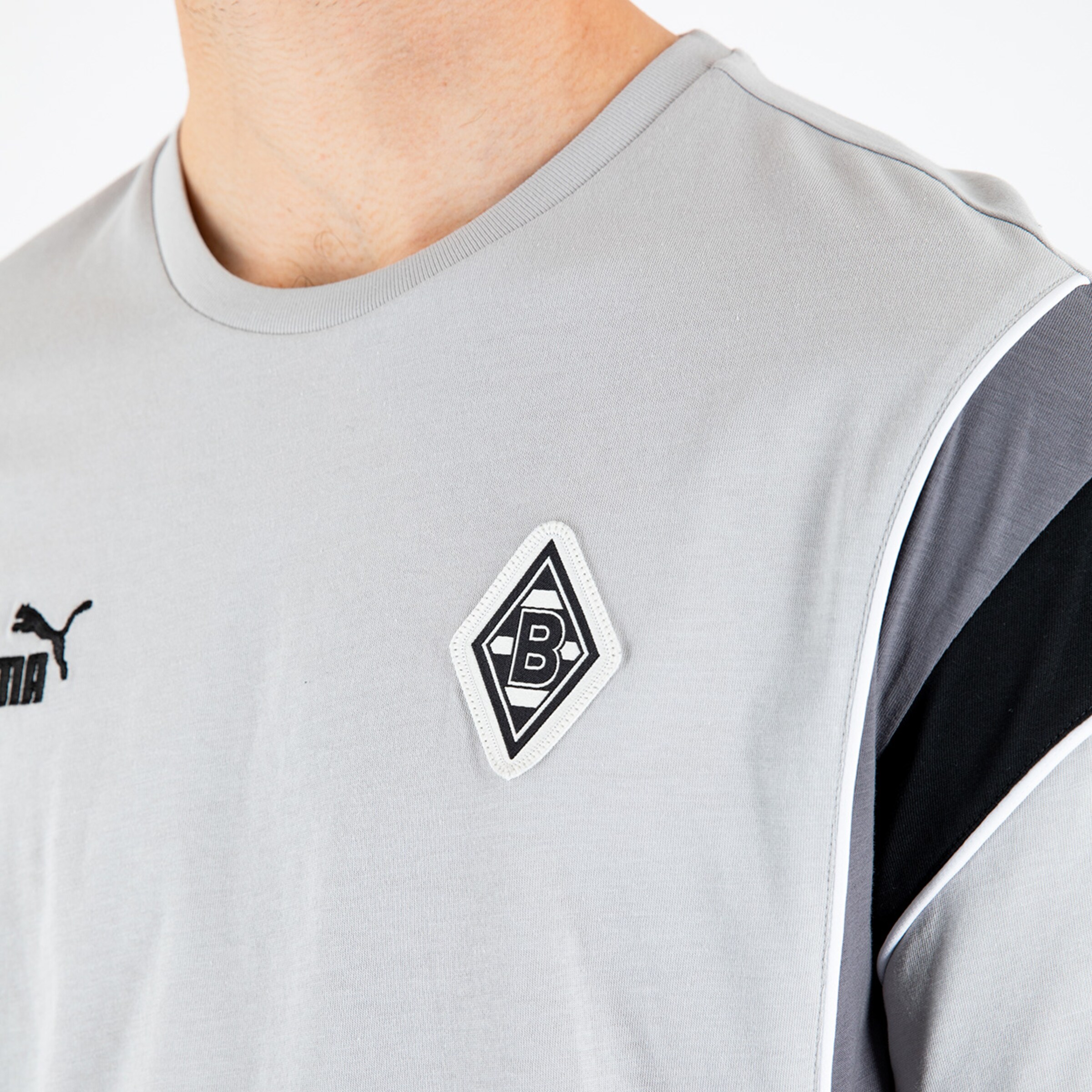 Grauweißes Trikot mit Borussia Mönchengladbach Logo und Puma Aufdruck.