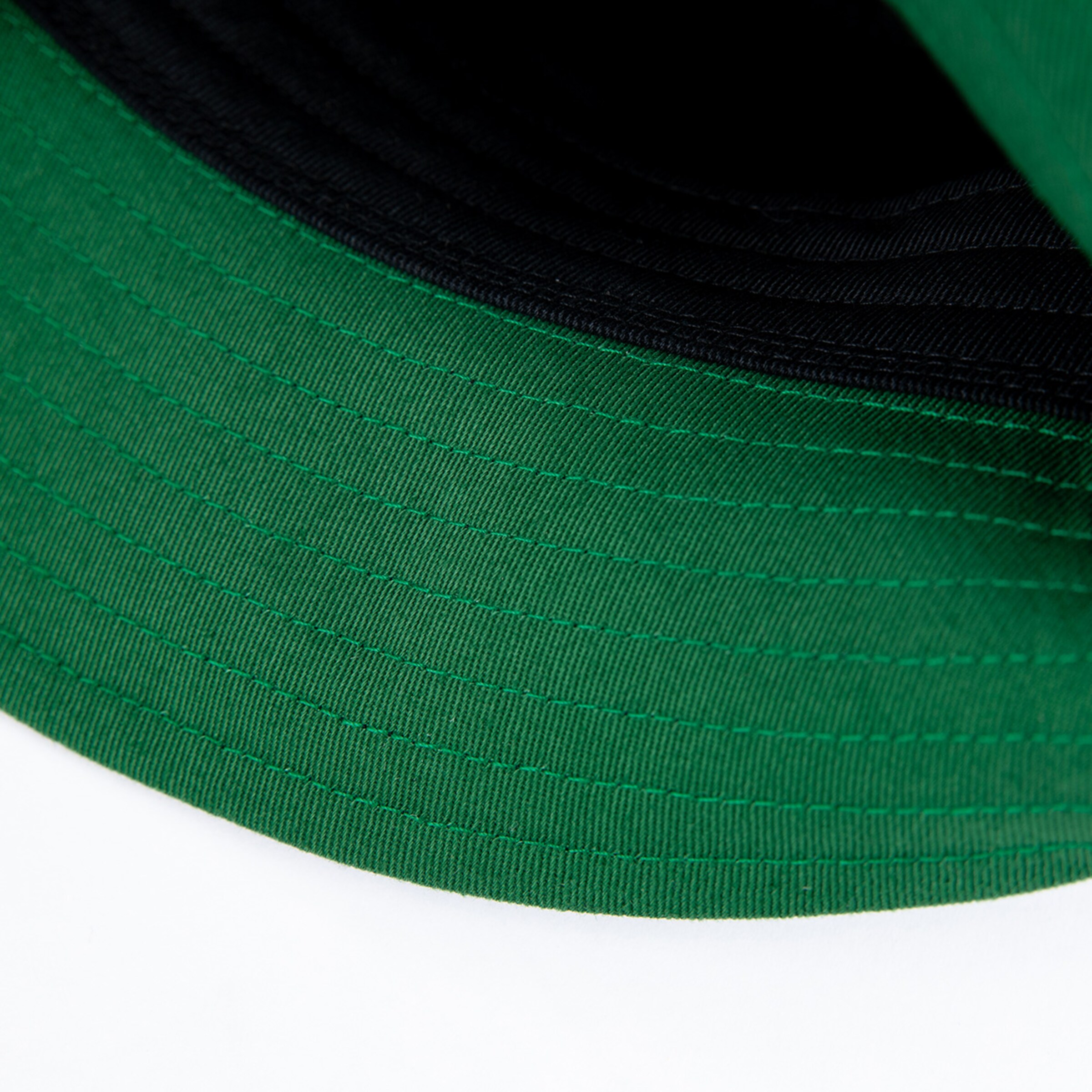 Grüner Schirm eines Baseballcaps auf weißem Hintergrund.