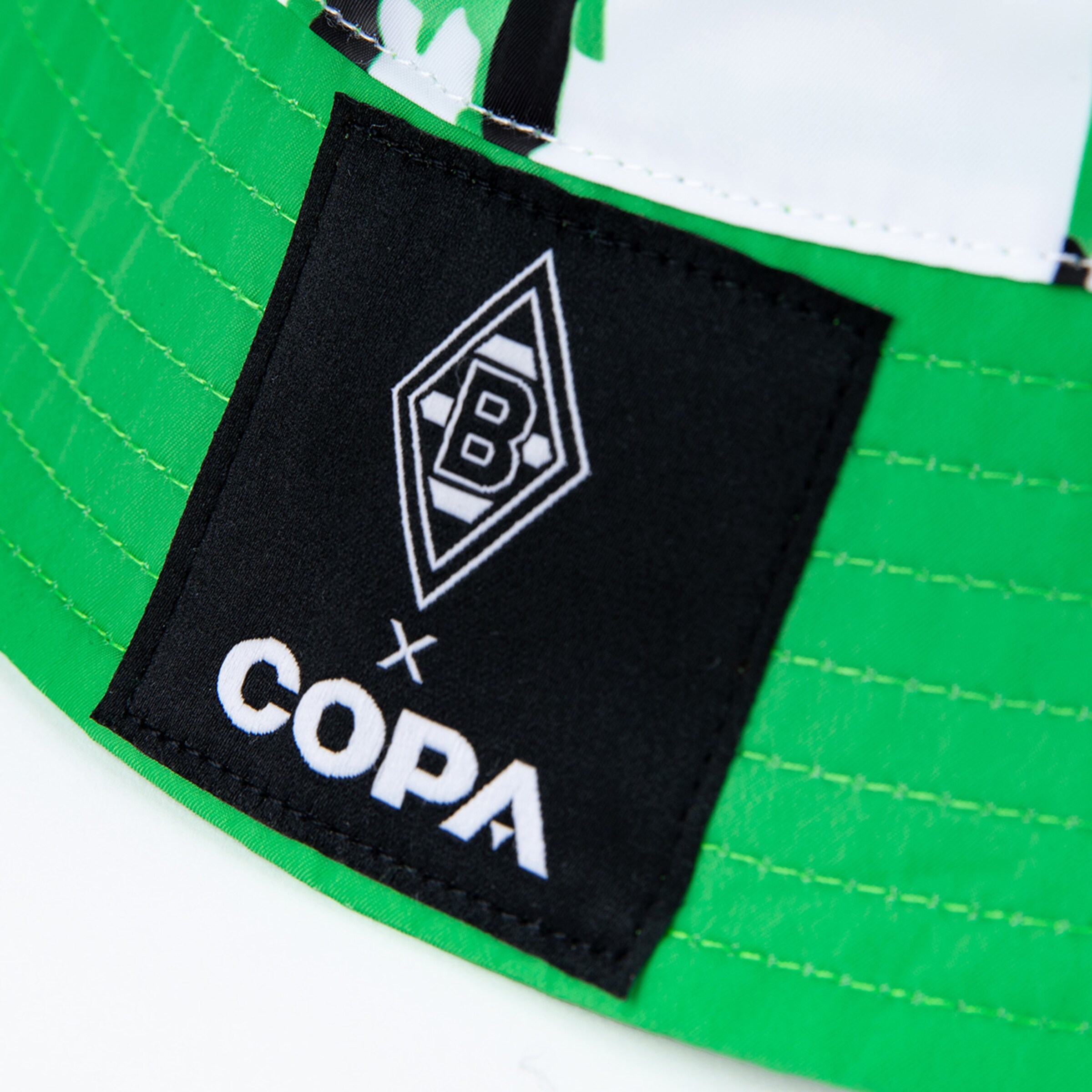 Schwarz-weißes Logo von Borussia Mönchengladbach und COPA auf einer grünen Kappe