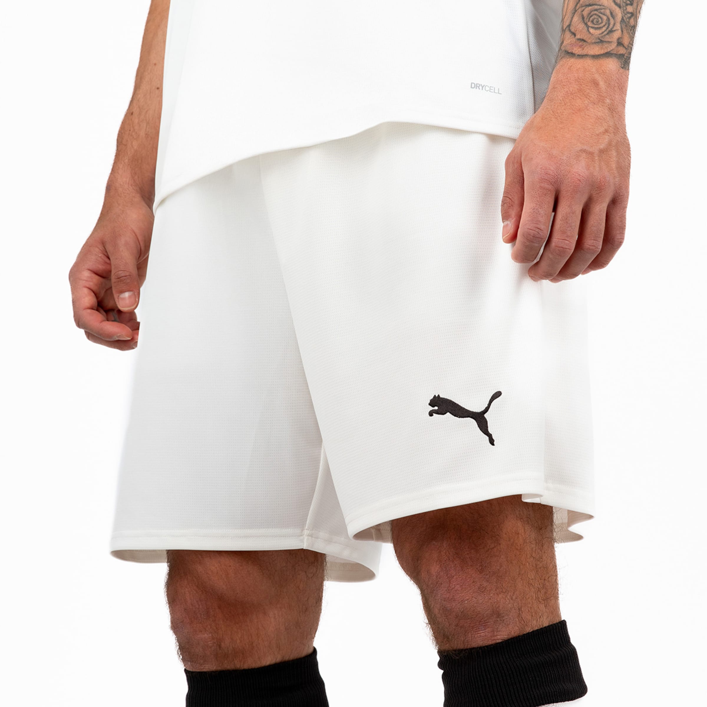 White sports shorts by Puma with a black logo worn by a man.