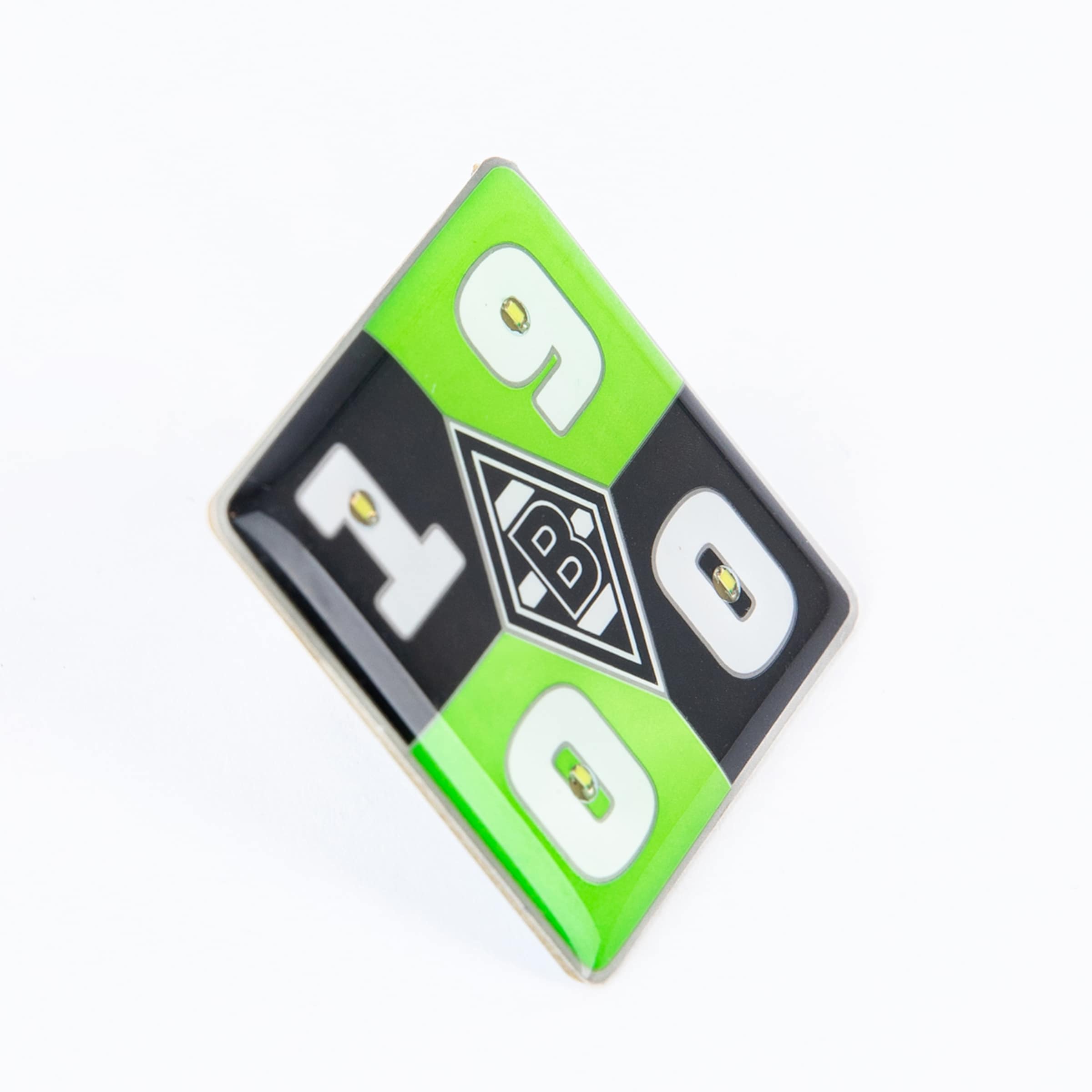 Rautenförmige Anstecknadel von Borussia Mönchengladbach in Grün und Schwarz mit der Jahreszahl 1900 und dem Vereinslogo in der Mitte.