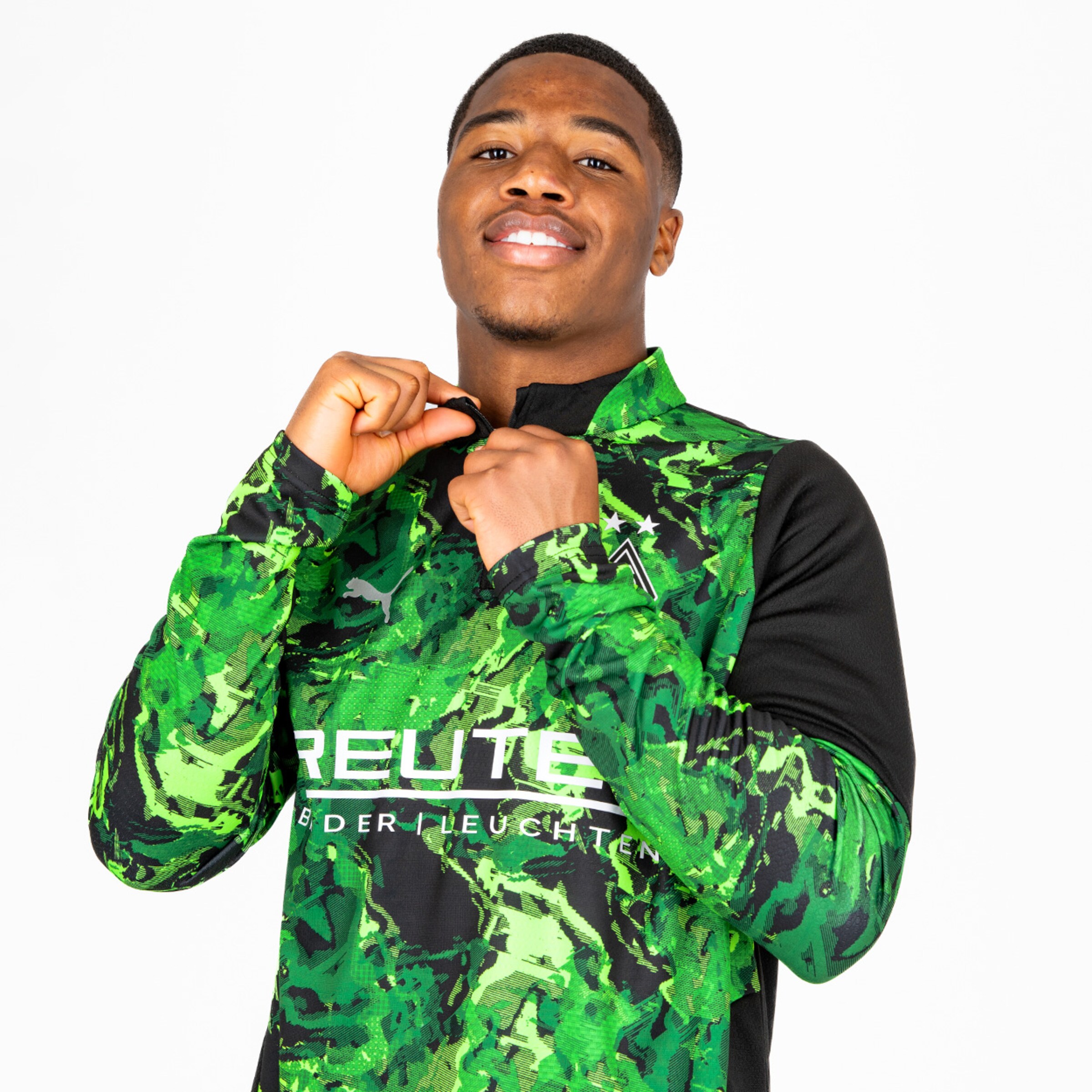 Spieler zeigt das Trikot mit der Sponsorenbeschriftung Reute.