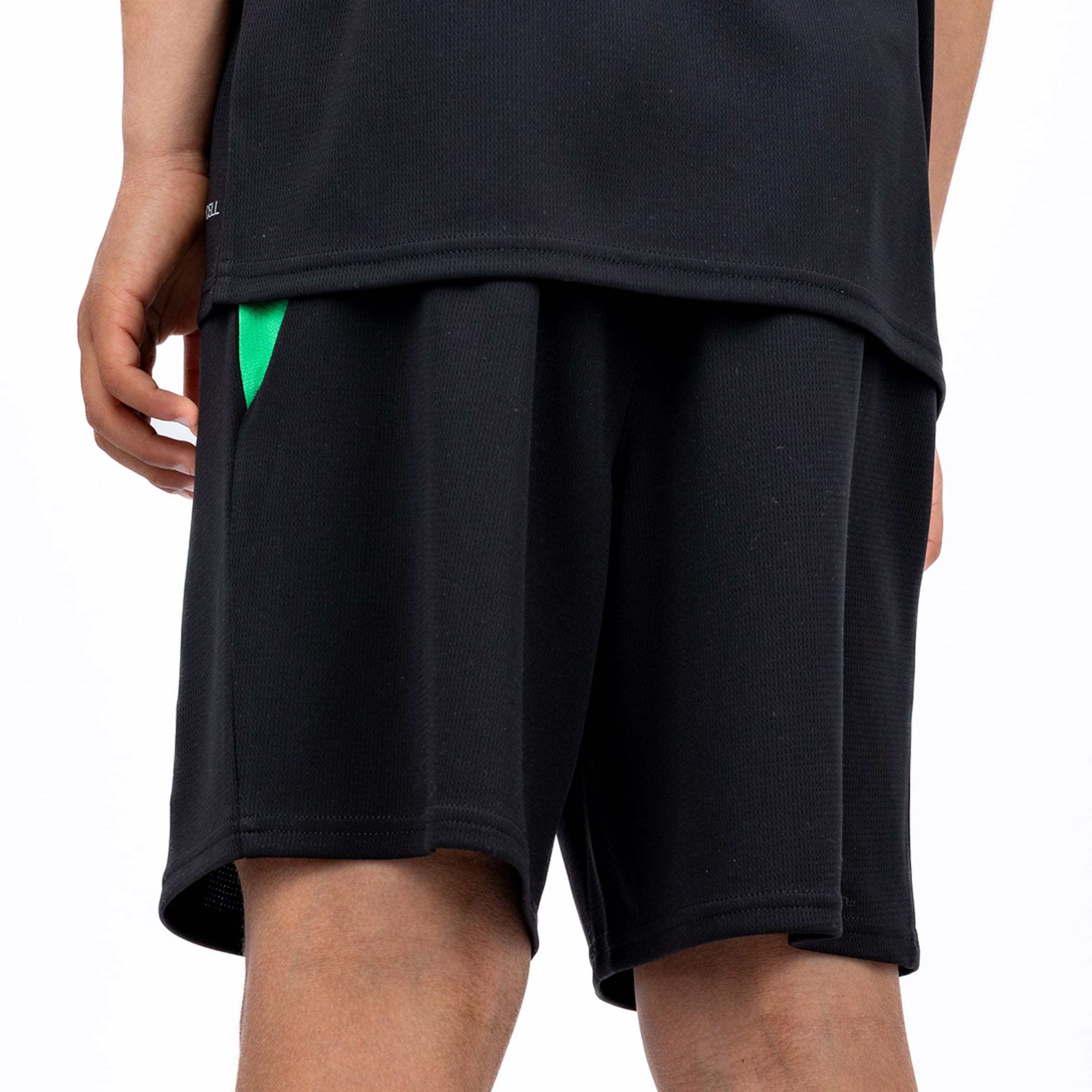 Rückansicht schwarzer Mesh-Sportshorts mit grünem Detail an der Tasche und schwarzem T-Shirt vor weißem Hintergrund.
