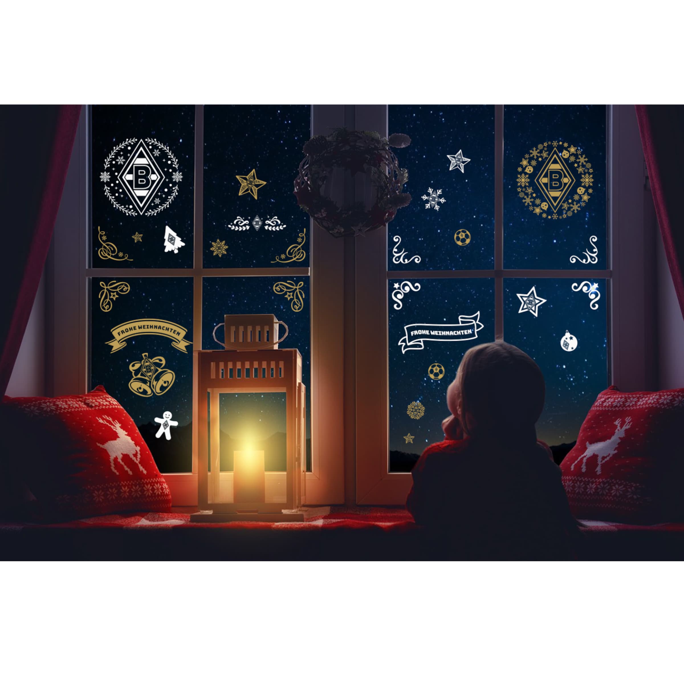 Kind sitzt am Fenster und betrachtet weihnachtliche Fensterdeko mit Borussia Mönchengladbach-Motiven.