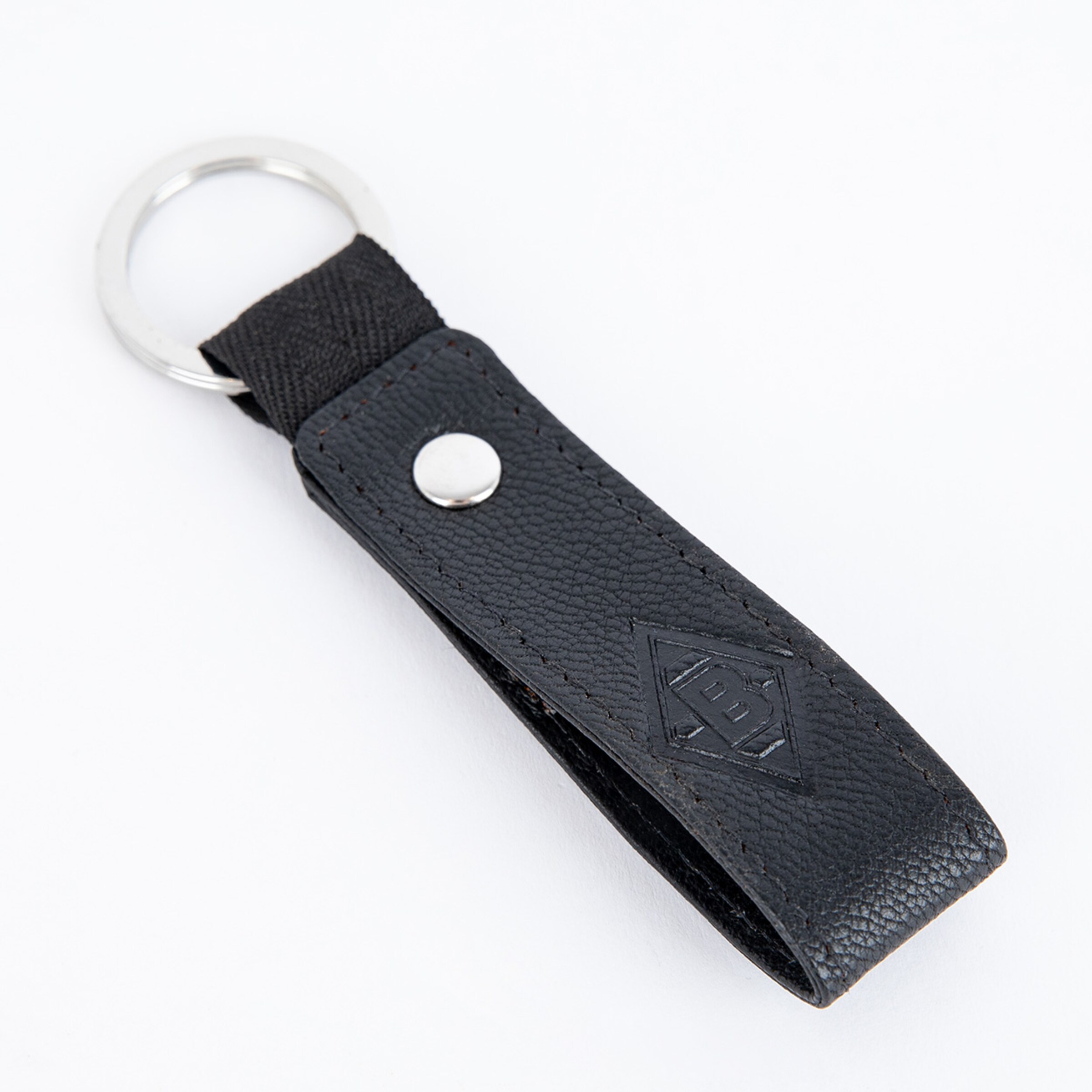 Schlüsselanhänger in Schwarz mit geprägtem Logo von Borussia Mönchengladbach.