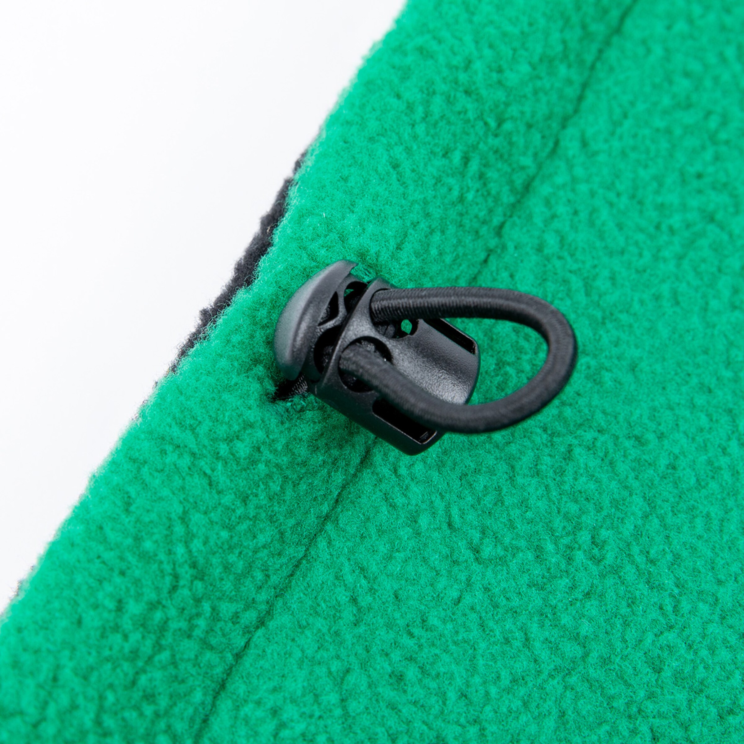 Detailansicht eines grünen Fleece-Stoffes mit Kordelzug und Zugstopper.