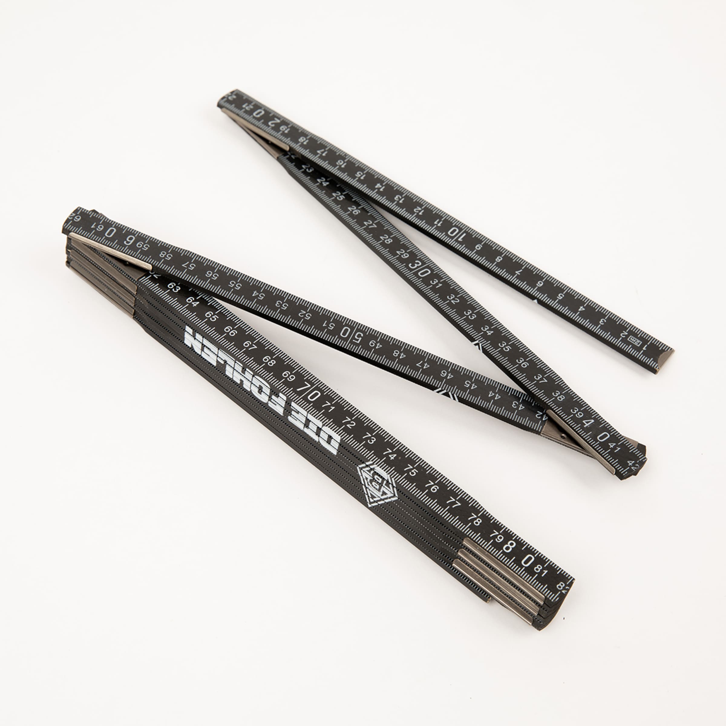 Black folding ruler set with numerical markings on the surface.