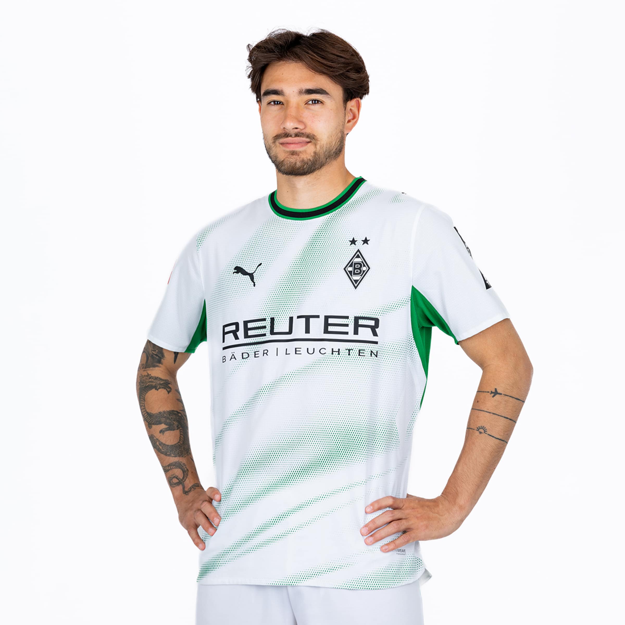 Football player Lukas Ullrich in the white Borussia Mönchengladbach home kit with green accents, hands on hips against a white background.