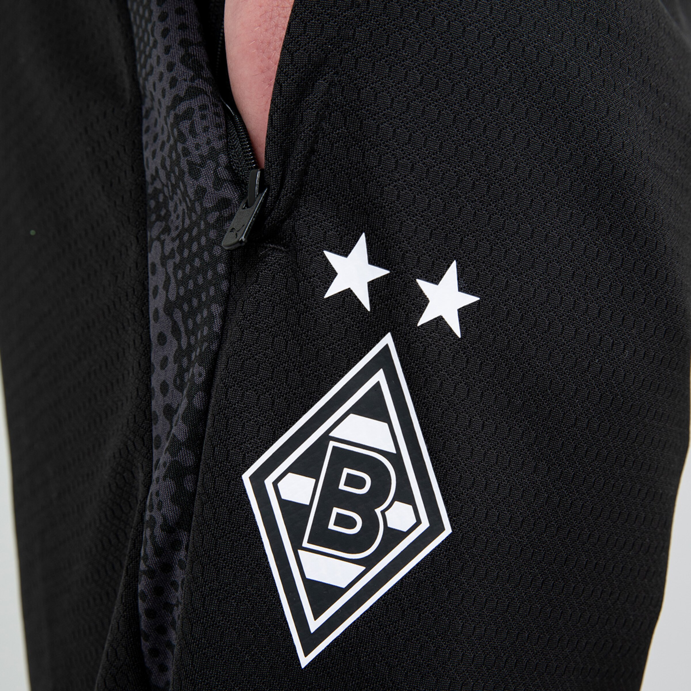 Detailaufnahme eines schwarzen Borussia Mönchengladbach Trikots mit dem Vereinslogo und zwei Sternen.