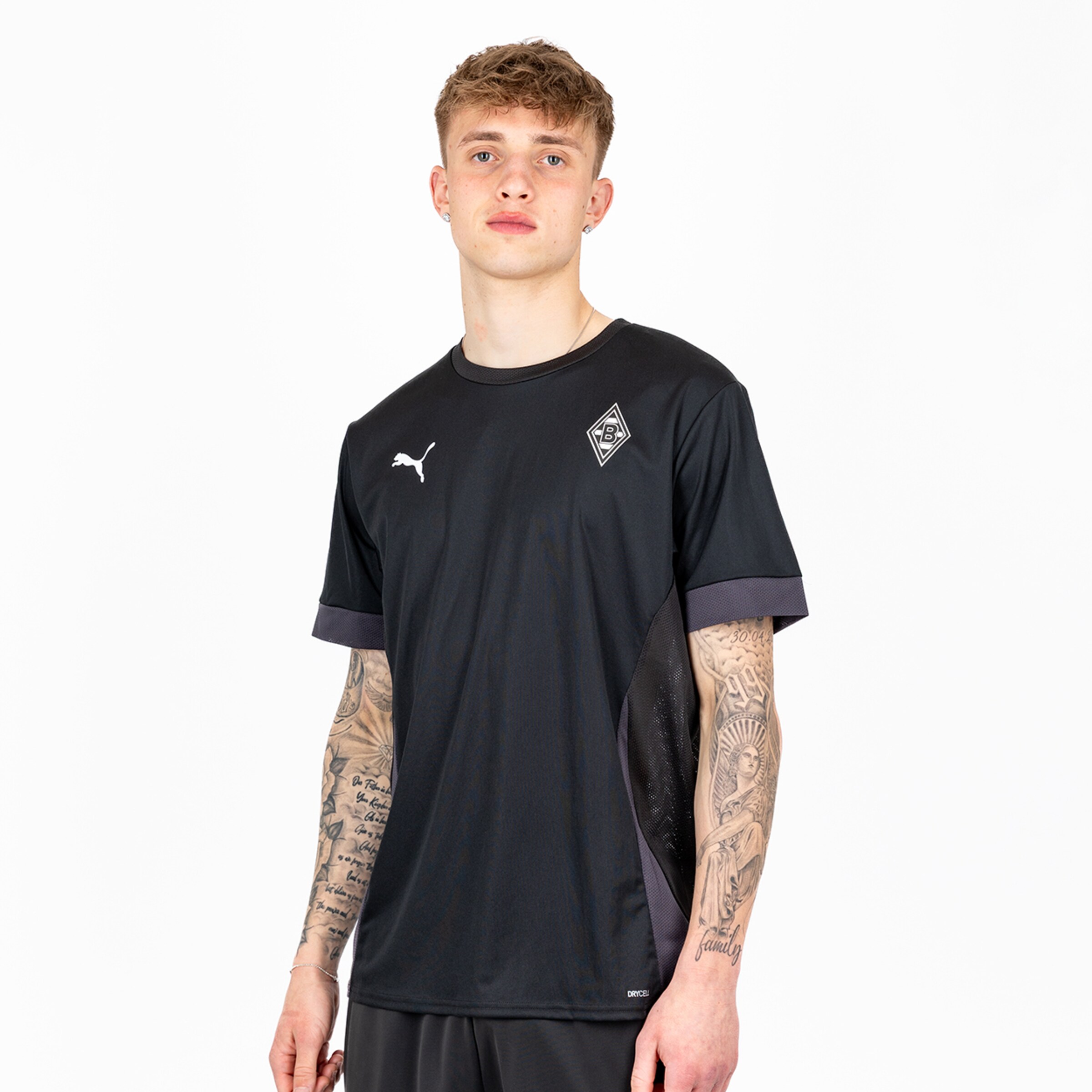 Teen wearing a black Borussia Mönchengladbach shirt with Puma logo and grey side panels.