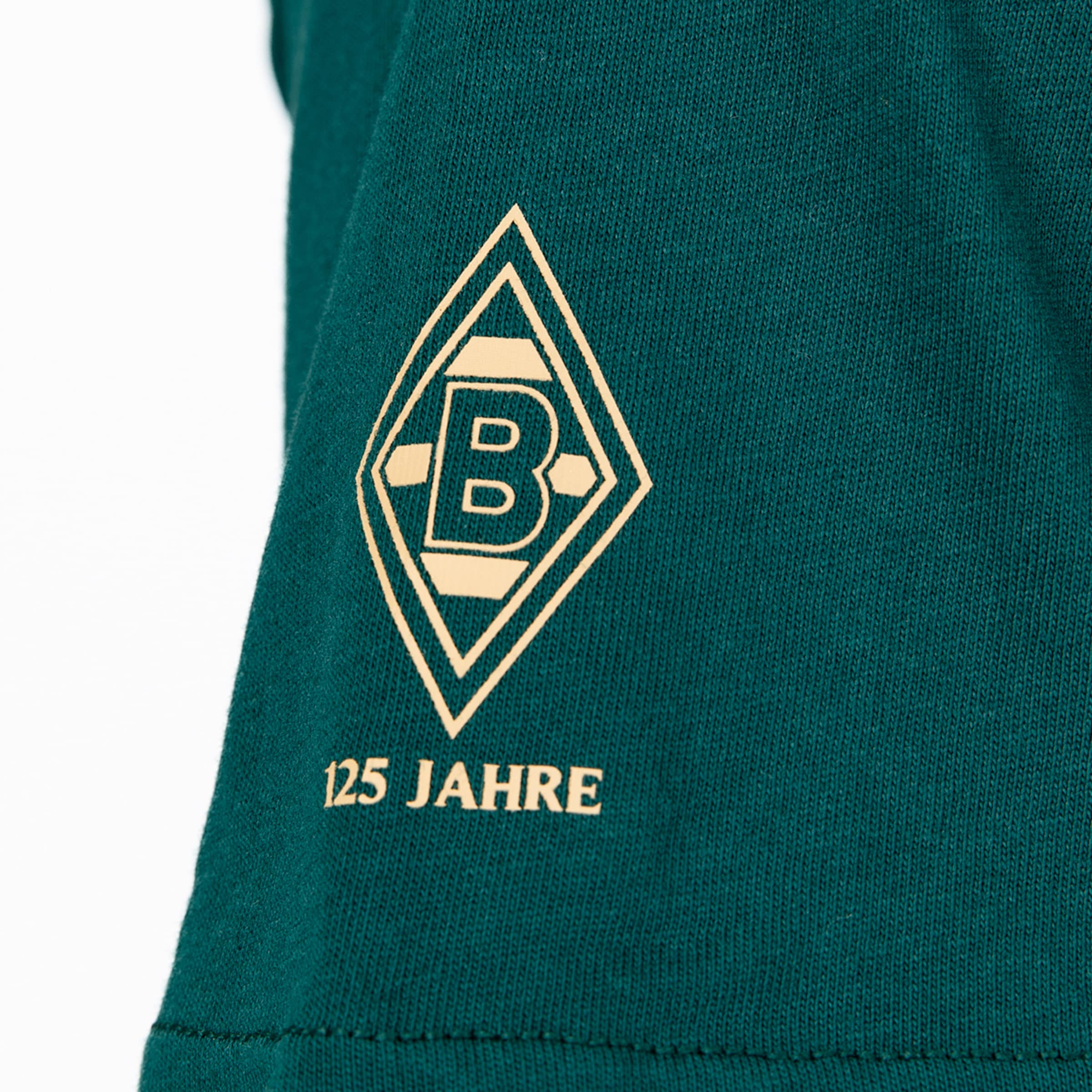 Goldener Druck auf grünem Stoff: Das Logo von Borussia Mönchengladbach in einer Raute mit dem Schriftzug „125 JAHRE“.