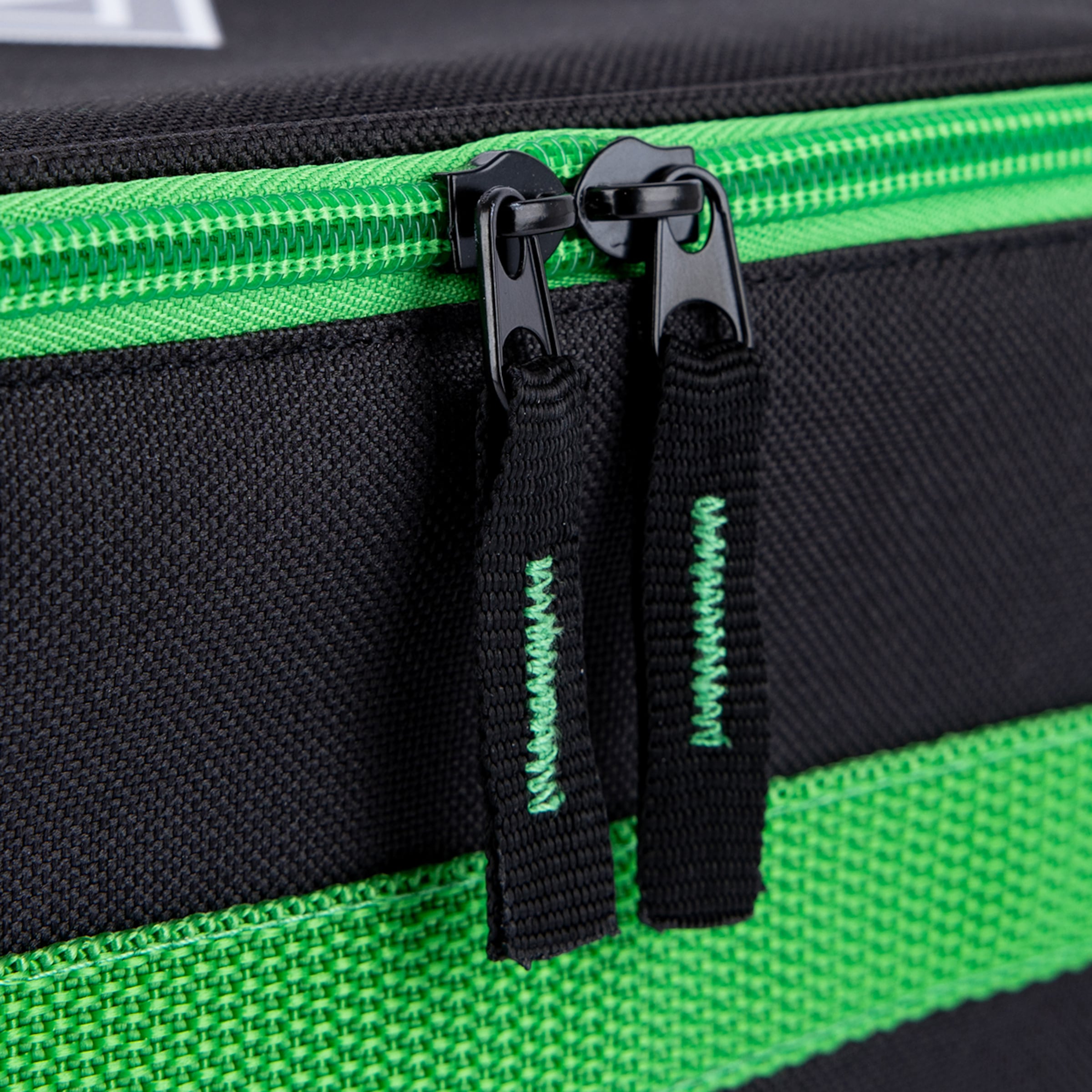 Nahaufnahme eines schwarzen Koffers mit neongrünem Reißverschluss und zwei schwarzen Zippern mit grüner Ziernaht.