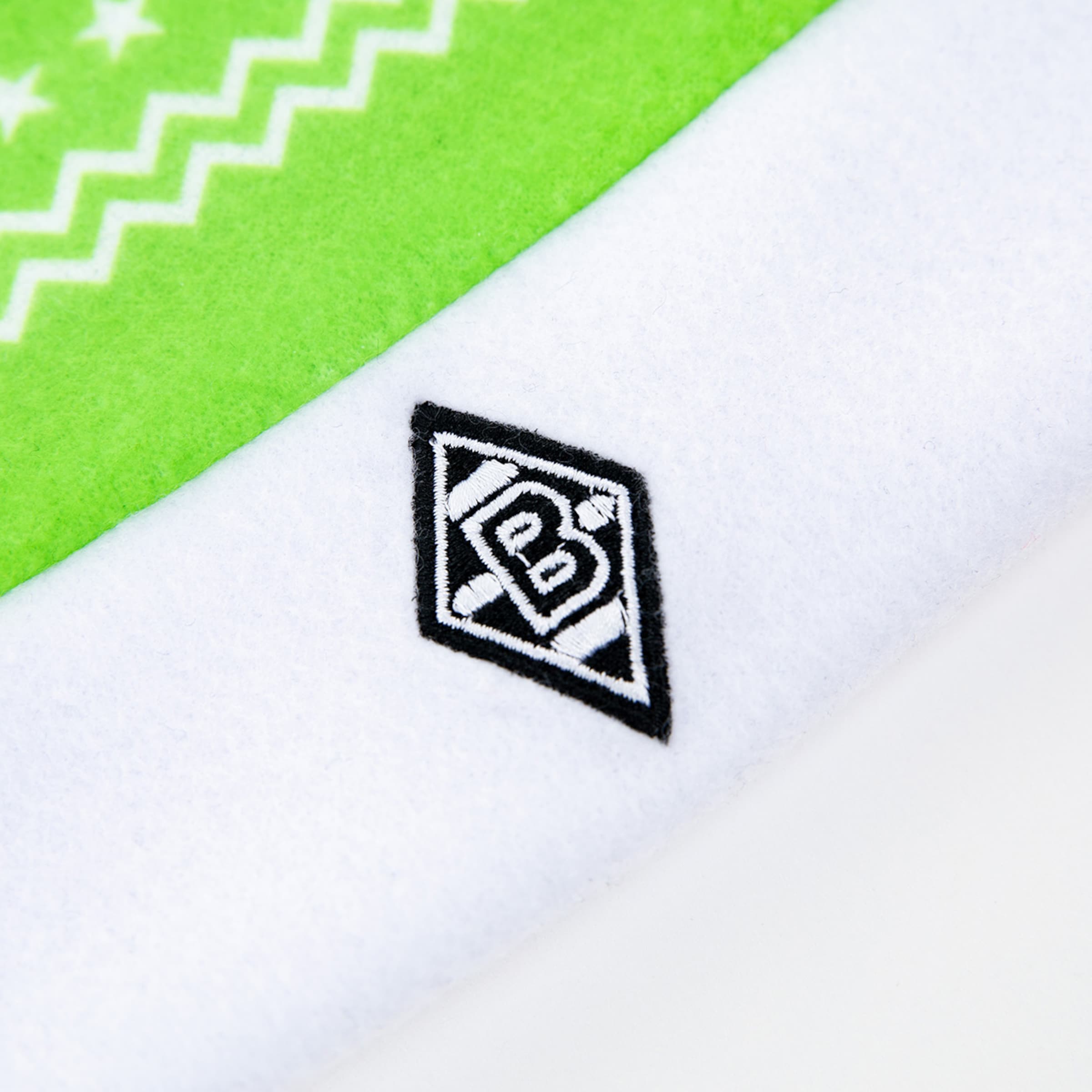 Emblem von Borussia Mönchengladbach auf einem weißen Textil mit grünem Hintergrund.