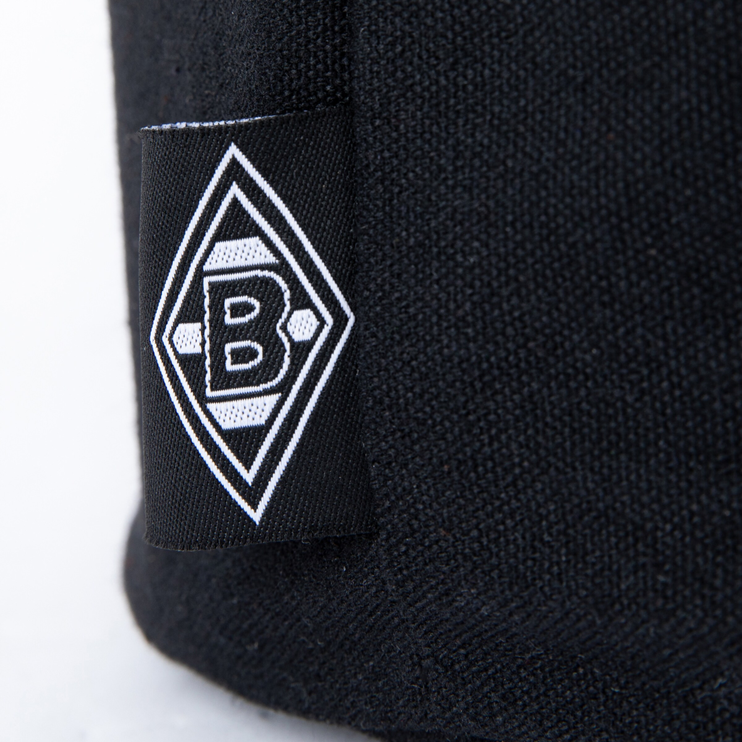 Black and white Borussia Mönchengladbach logo patch on black fabric.