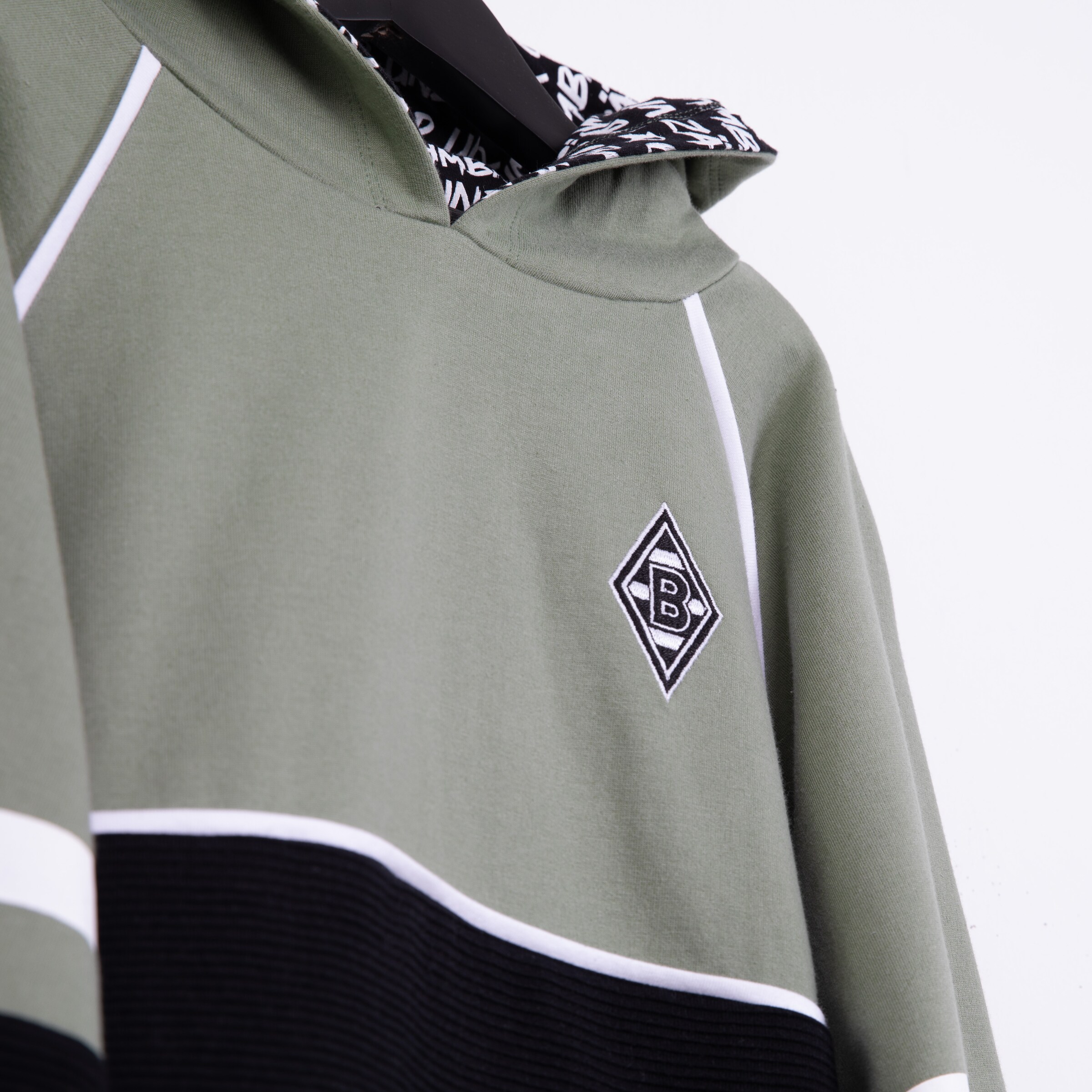 Graue Kapuzenjacke mit schwarzem und weißen Streifen sowie Borussia Mönchengladbach Logo.