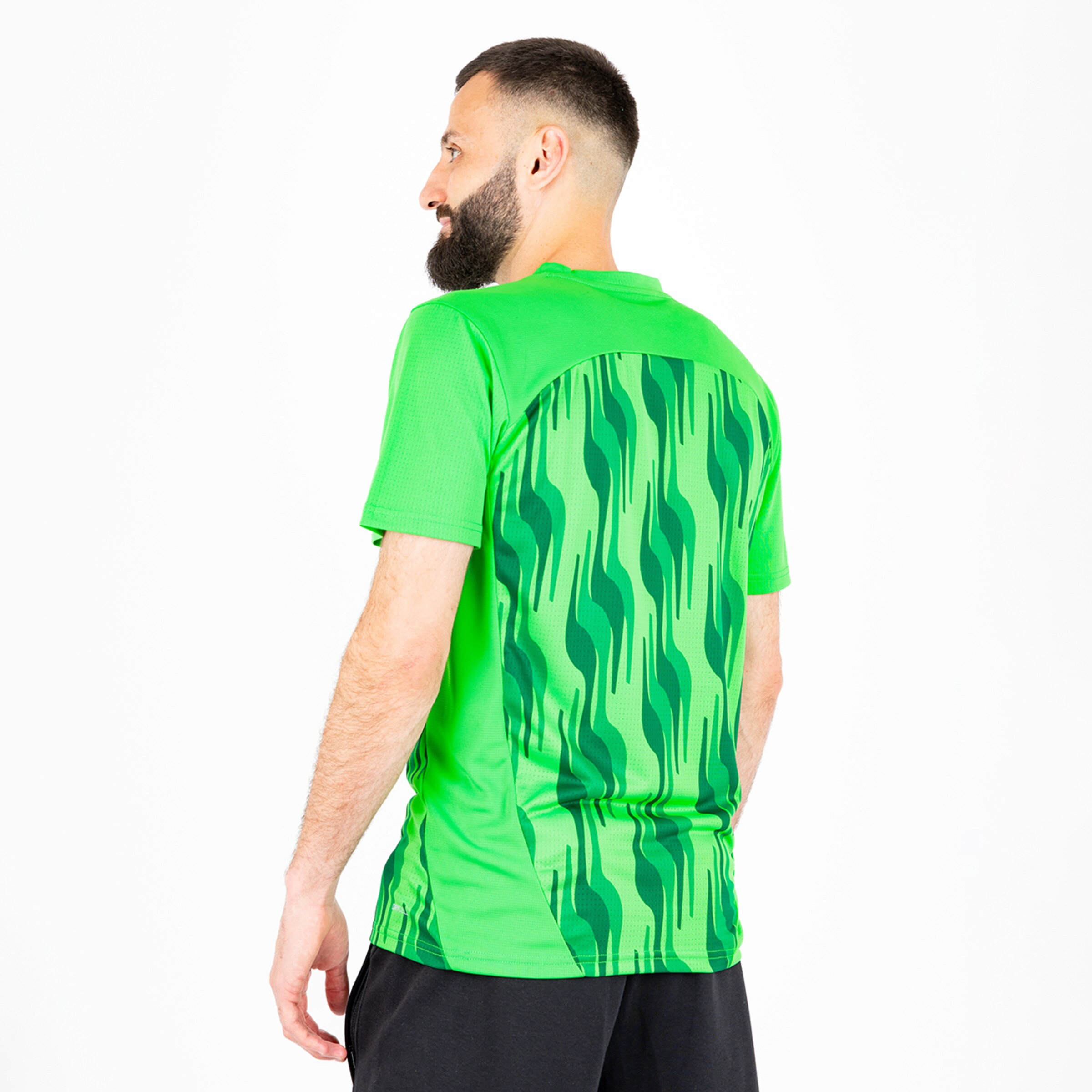 Mann mit Bart trägt ein grünes Sportshirt mit Wellenmuster auf dem Rücken.