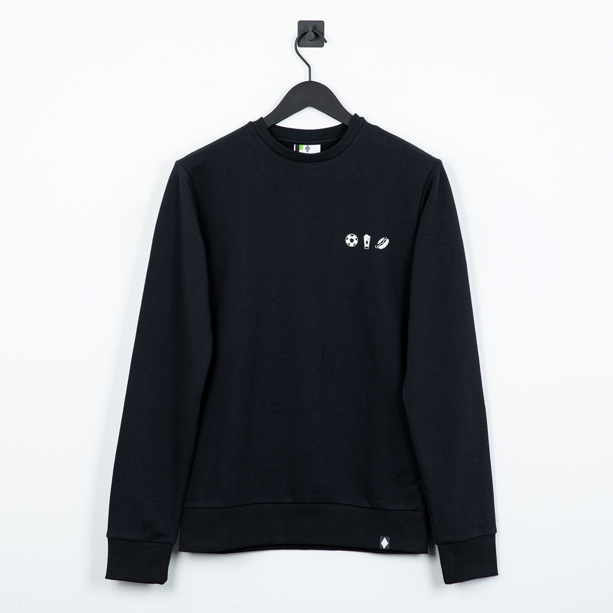 Schwarzes Sweatshirt mit weißen Symbolen (Fußball, Getränk, Bratwurst) auf der Brust, auf einem Bügel vor weißem Hintergrund.