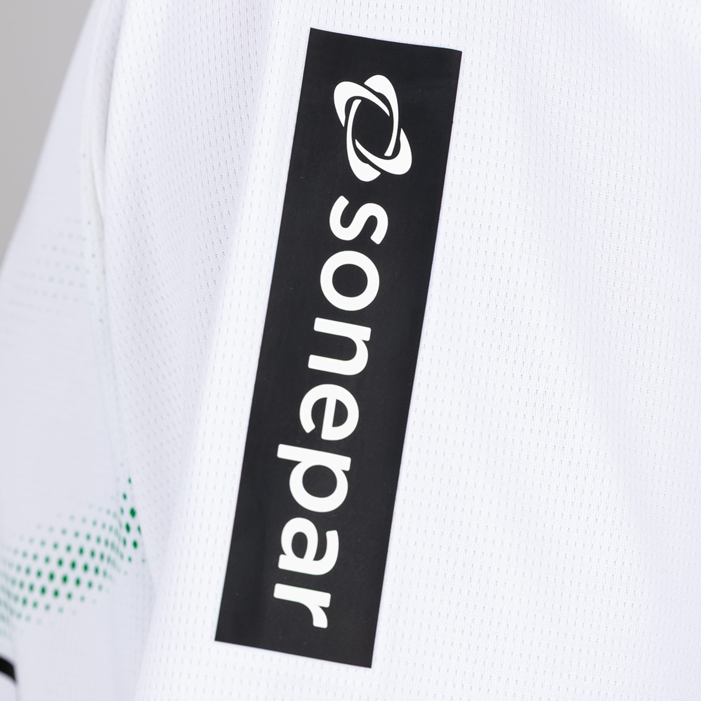 Nahaufnahme des weißen Sonepar-Schriftzugs und Logos auf einem vertikalen schwarzen Patch auf dem Ärmel eines weißen Trikots.