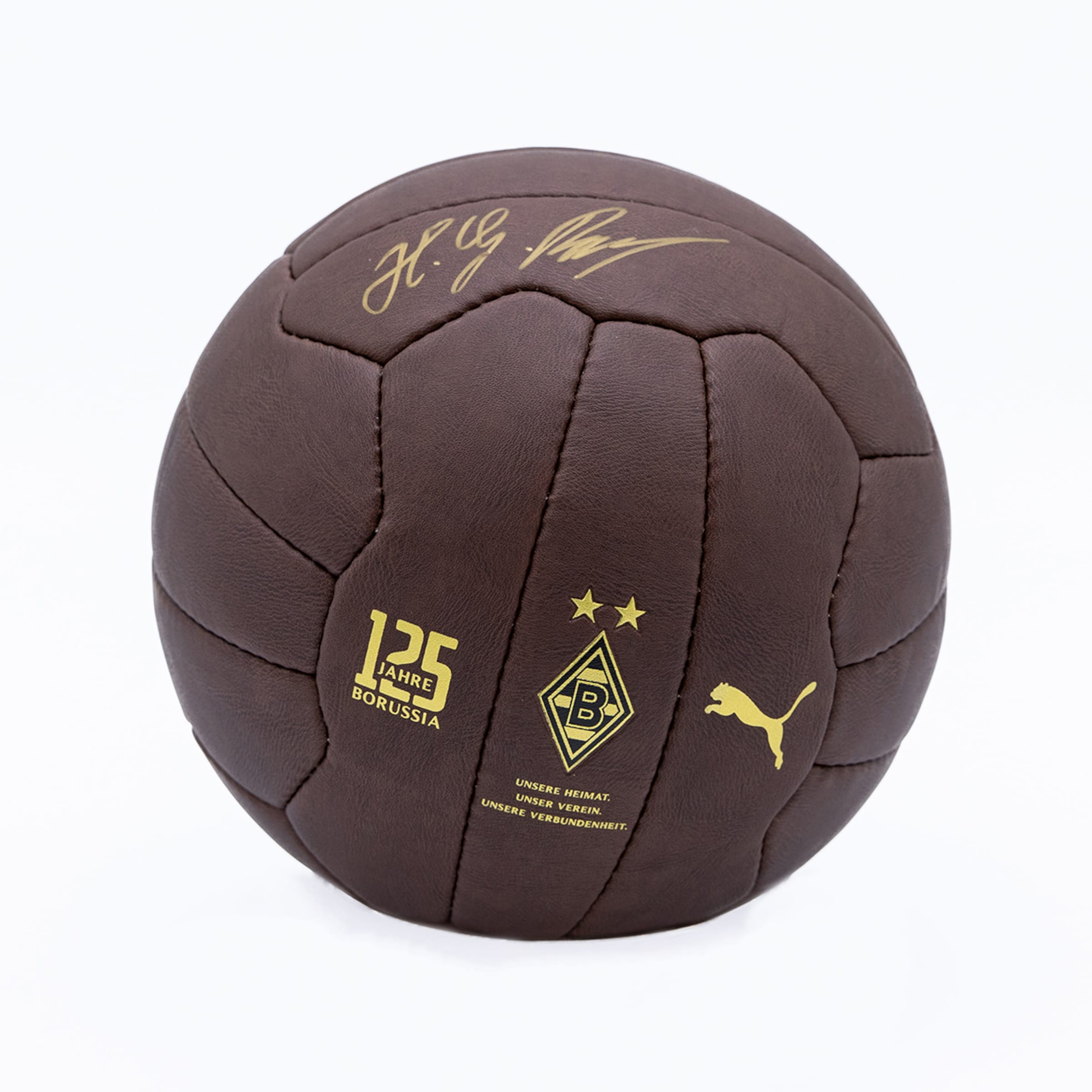 Brown Puma vintage leather football for Borussia Mönchengladbach's 125th anniversary with gold logos and signature on white background.