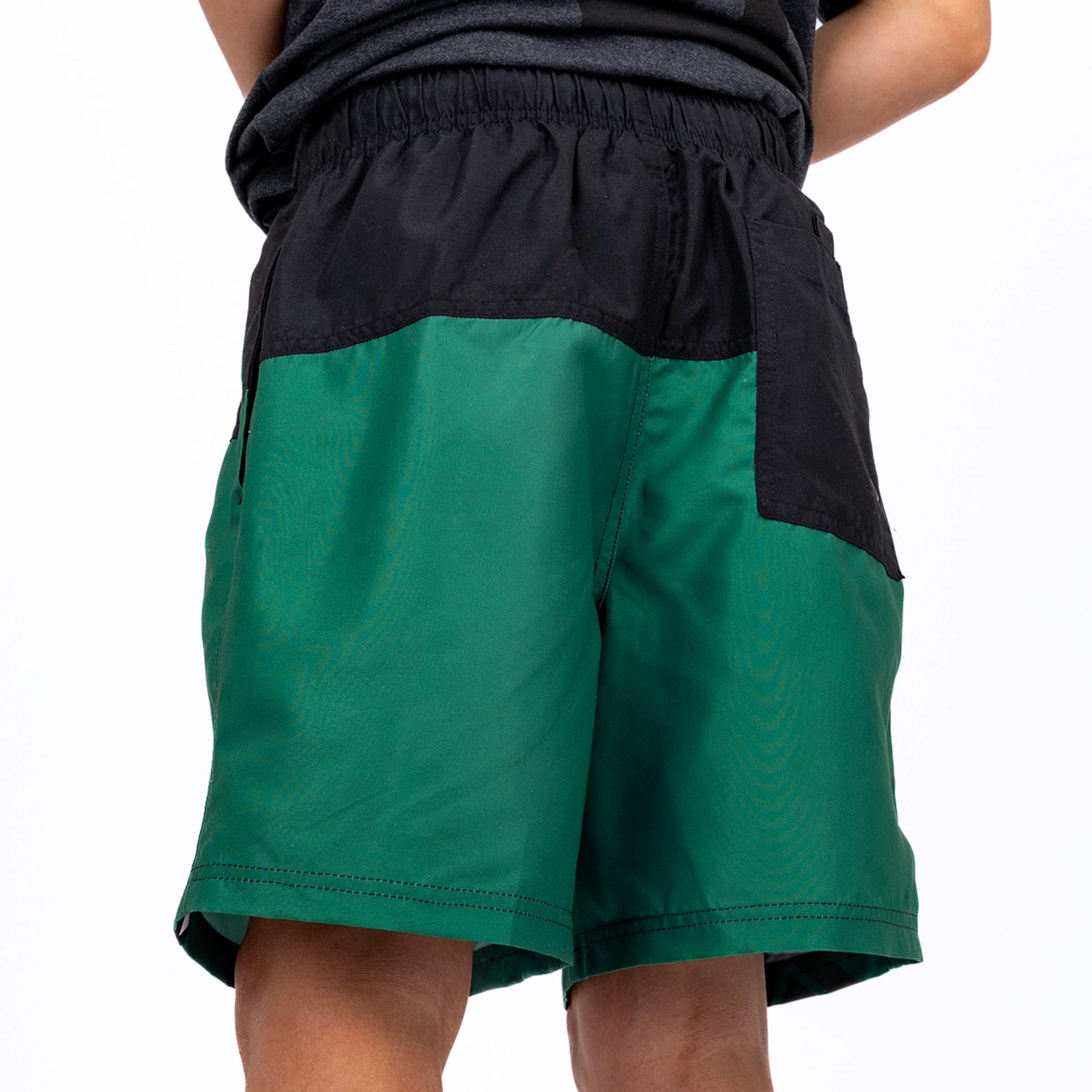 Back view of a person wearing two-tone shorts. The upper part is black, and the lower part is dark green, featuring an elasticated waist.