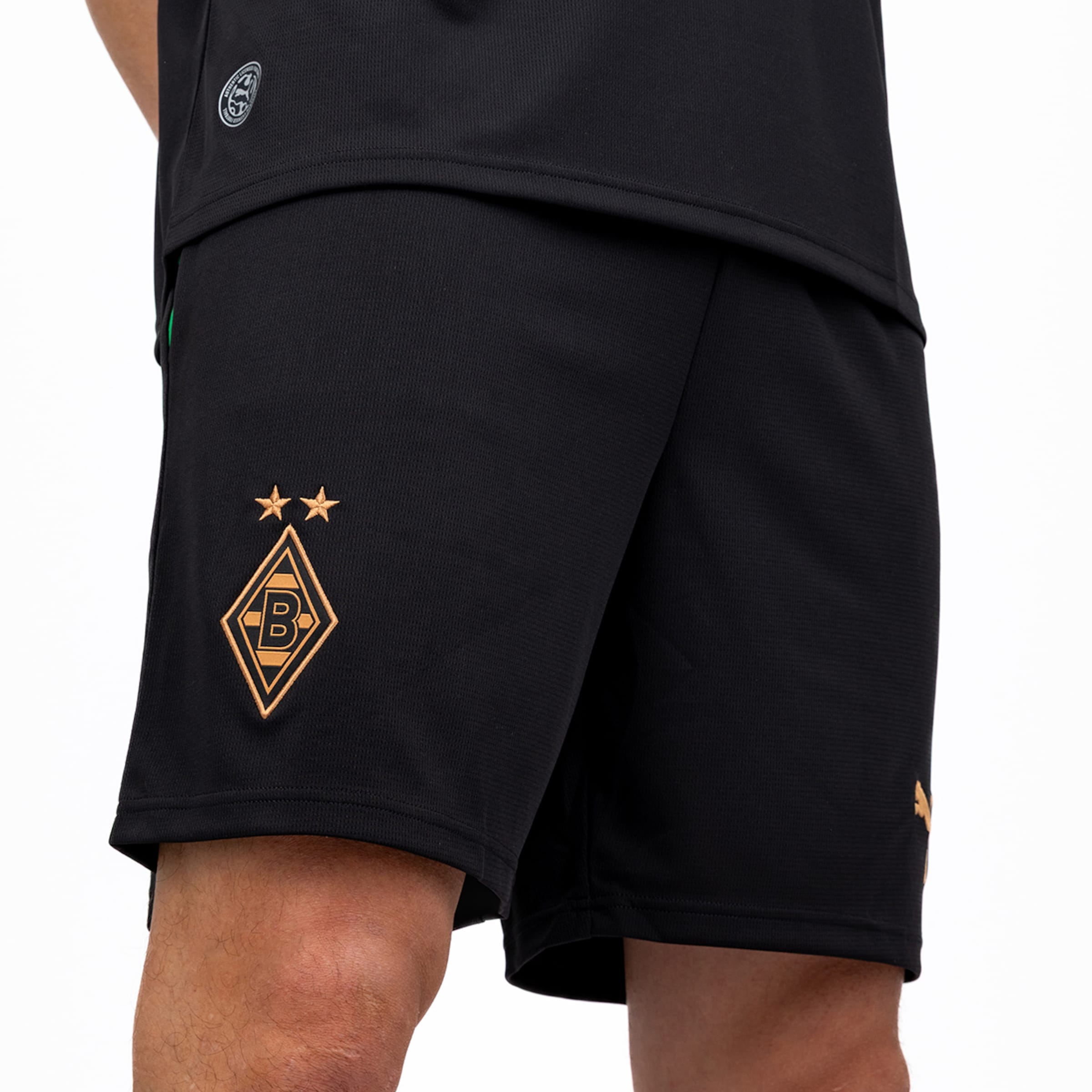 Schwarze Borussia Mönchengladbach Shorts mit goldfarbenem Vereinswappen und zwei Sternen auf dem Bein sowie Puma-Logo.