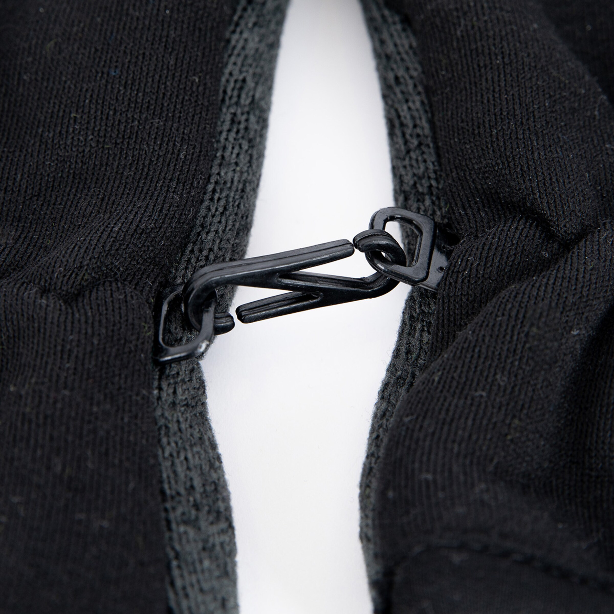 Detailaufnahme des Reißverschlusses an einem schwarzen Kleidungsstück.