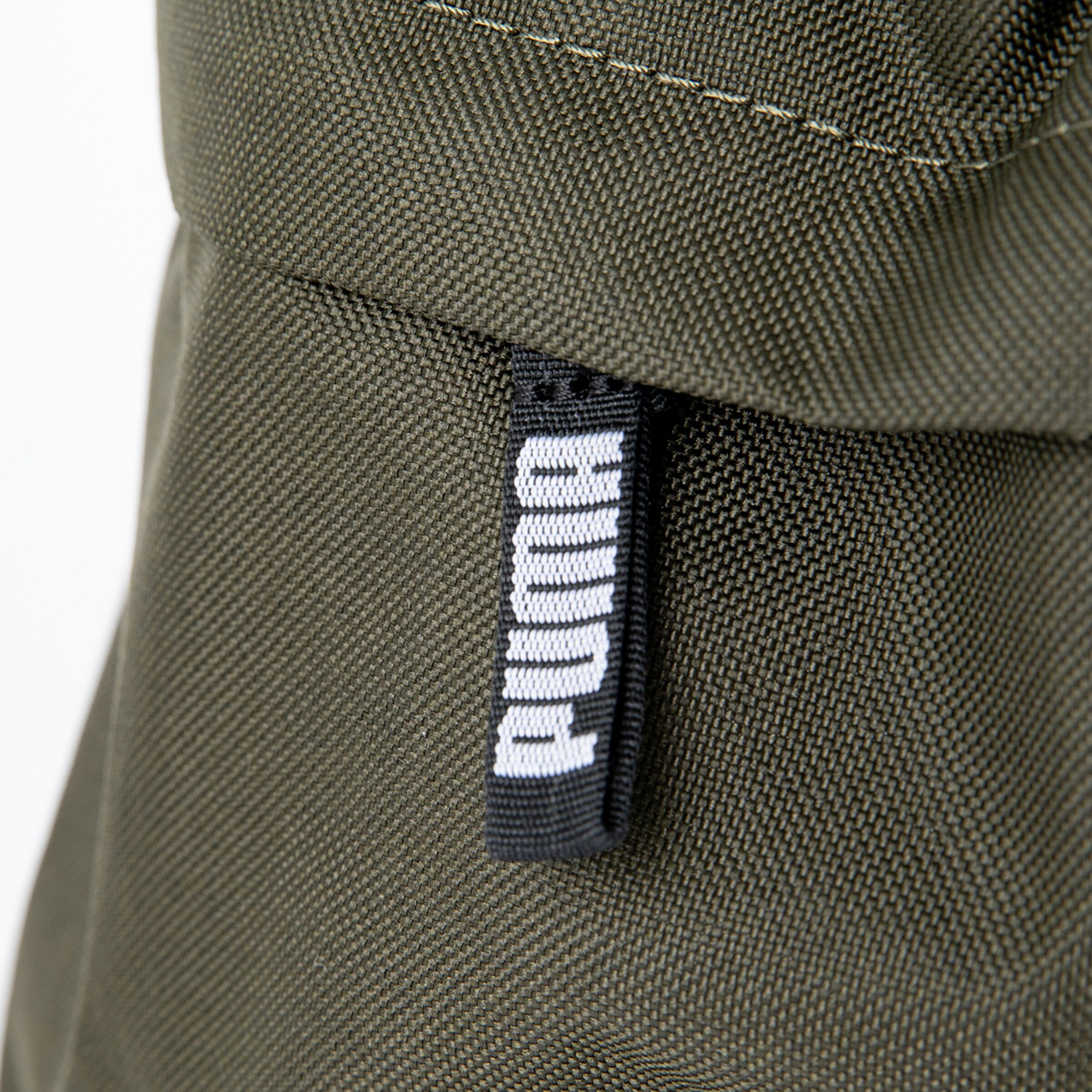 Nahaufnahme des Puma-Reißverschlusses an einer Tasche in Olivgrün.