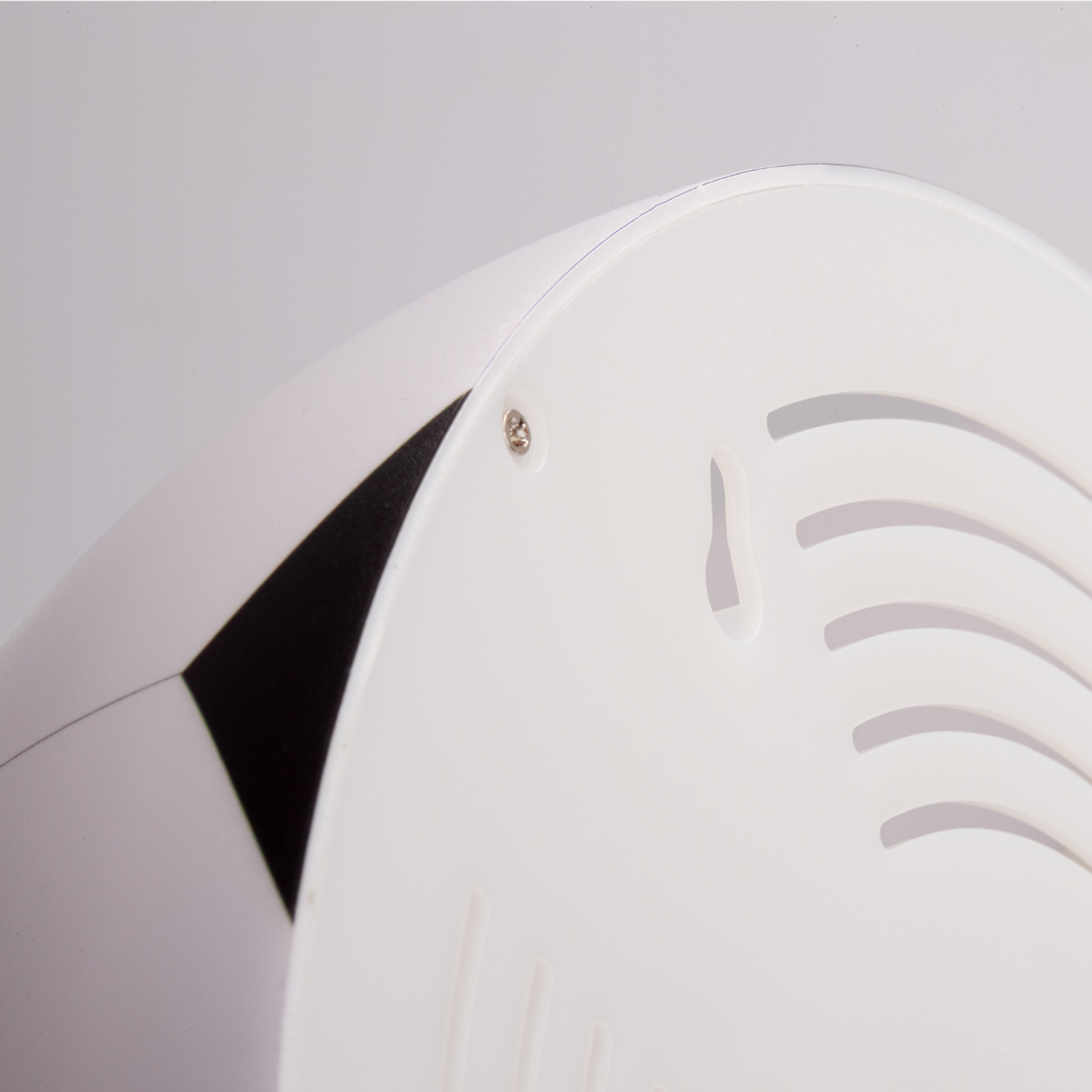 Detailansicht der Rückseite eines weißen Geräts mit Lüftungsschlitzen.